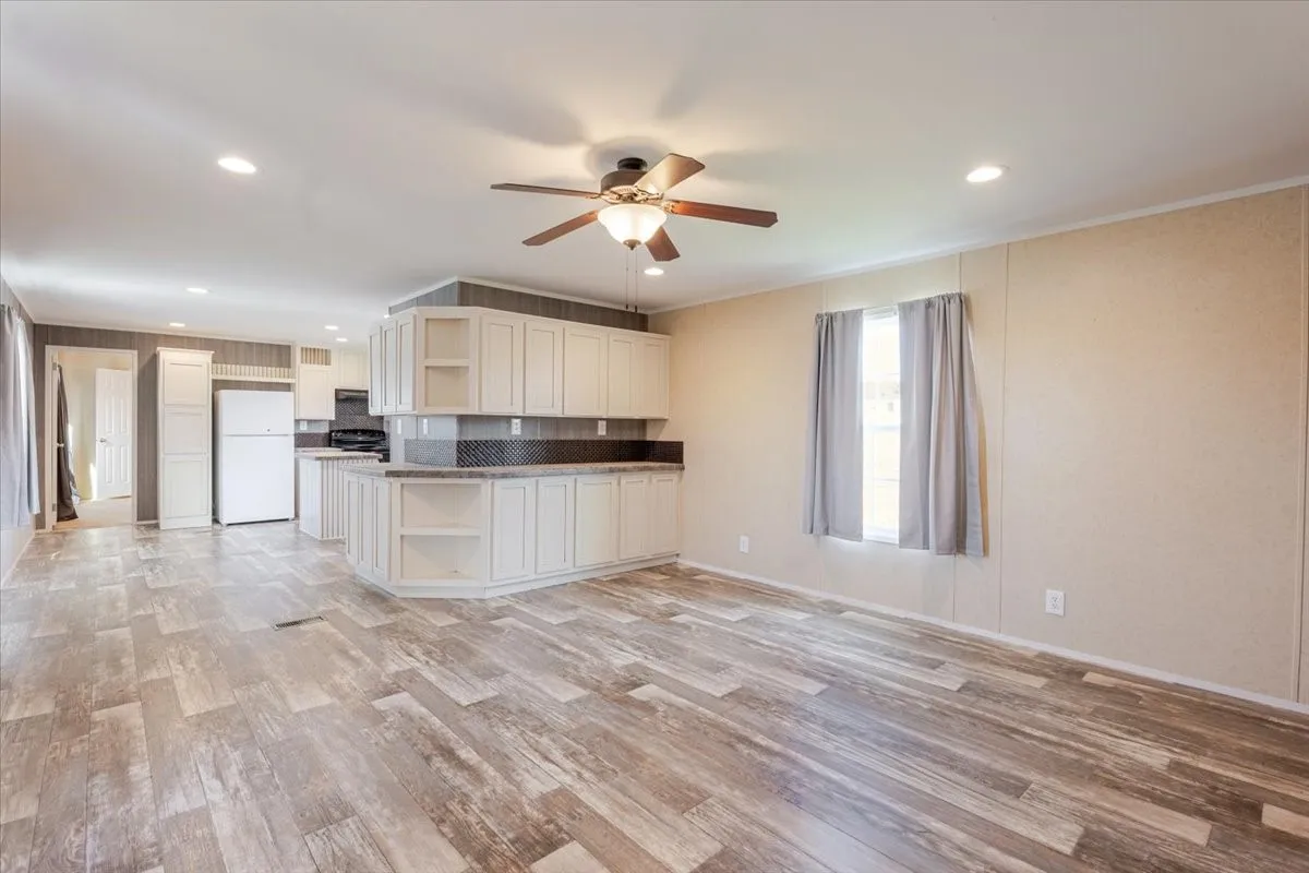 Open-concept living space featuring wood-finish flooring, recessed lighting, and a ceiling fan