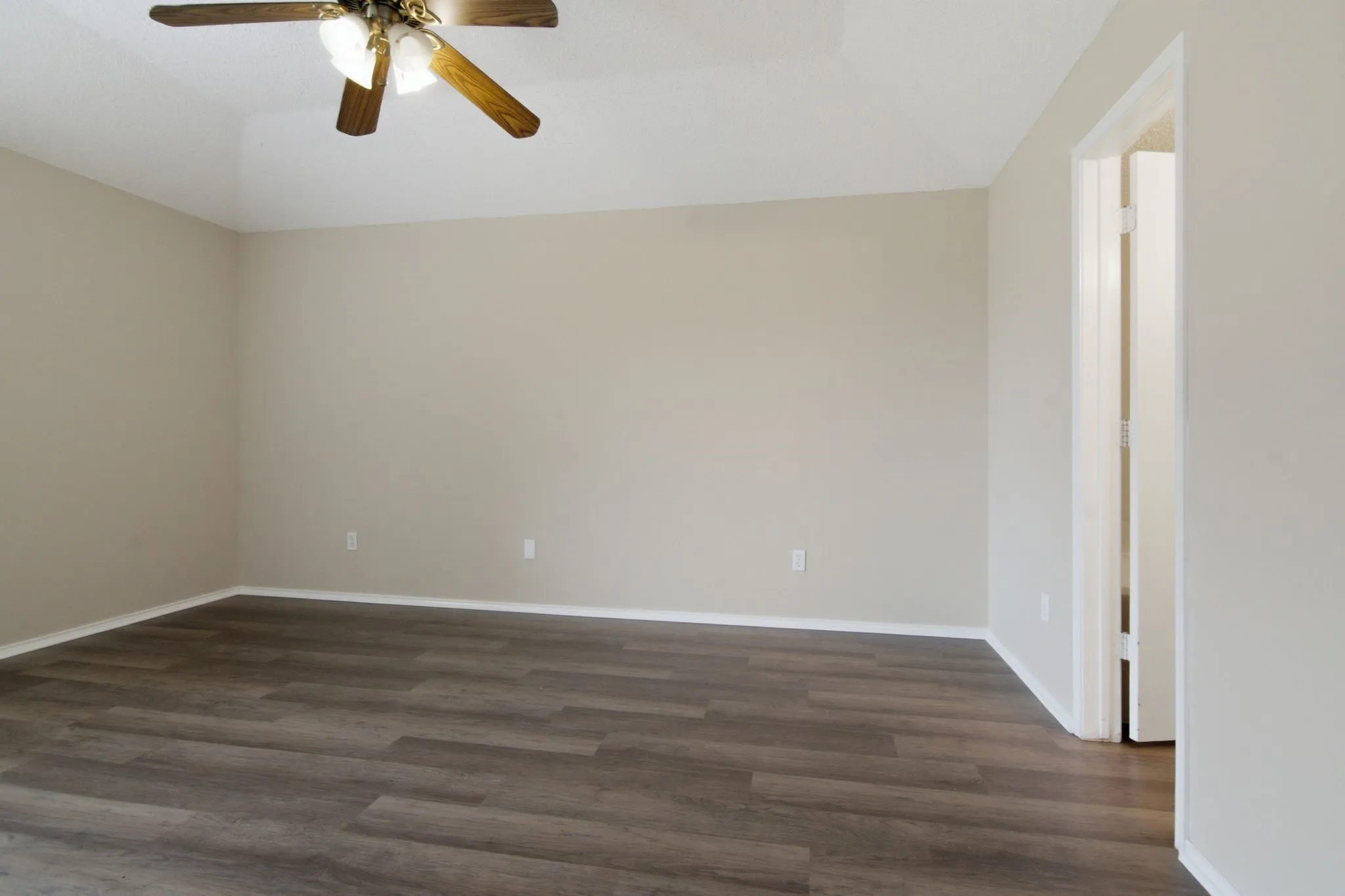 Wood-finish flooring with neutral wall tones and a ceiling fan