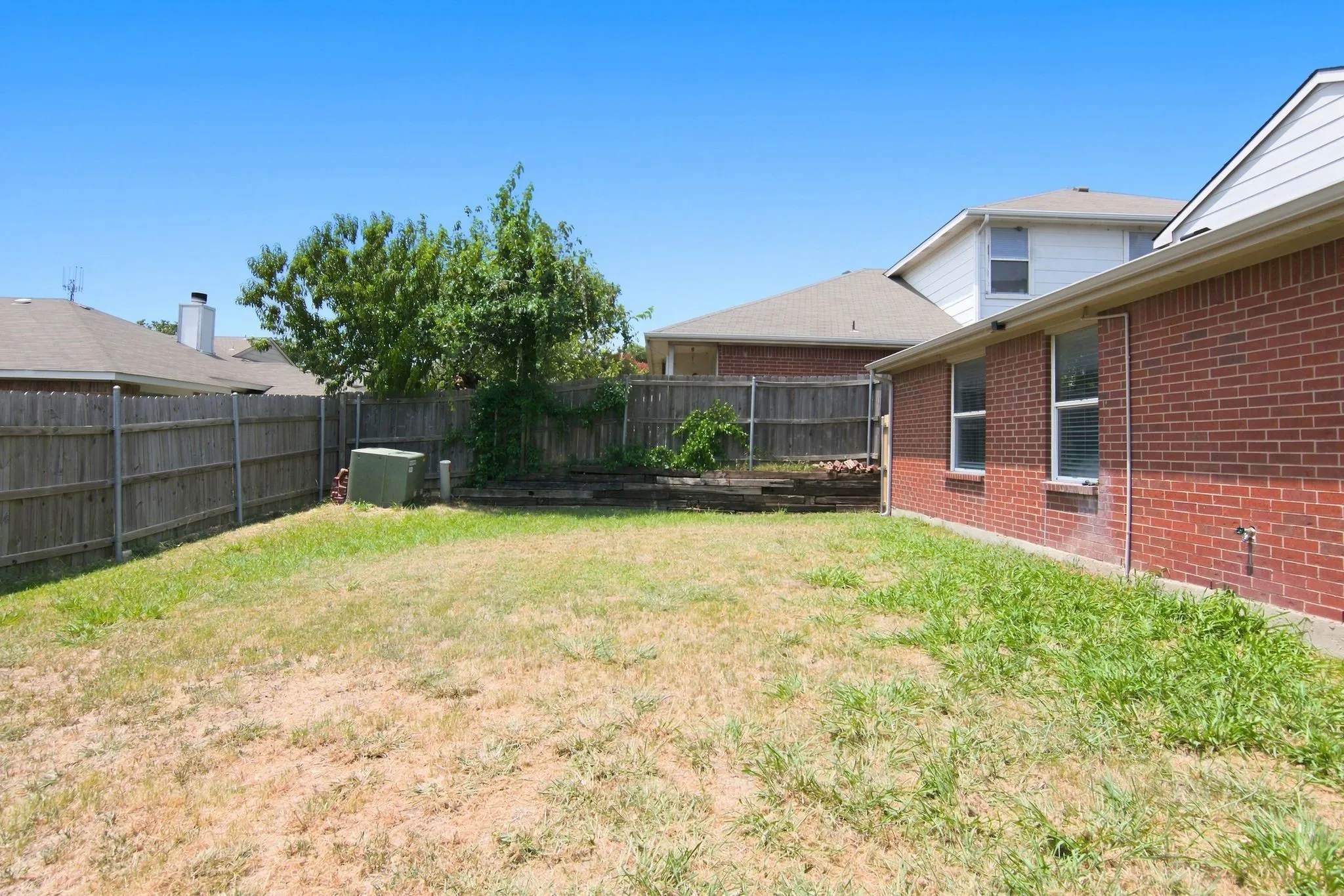 Expansive backyard area with a full privacy fence