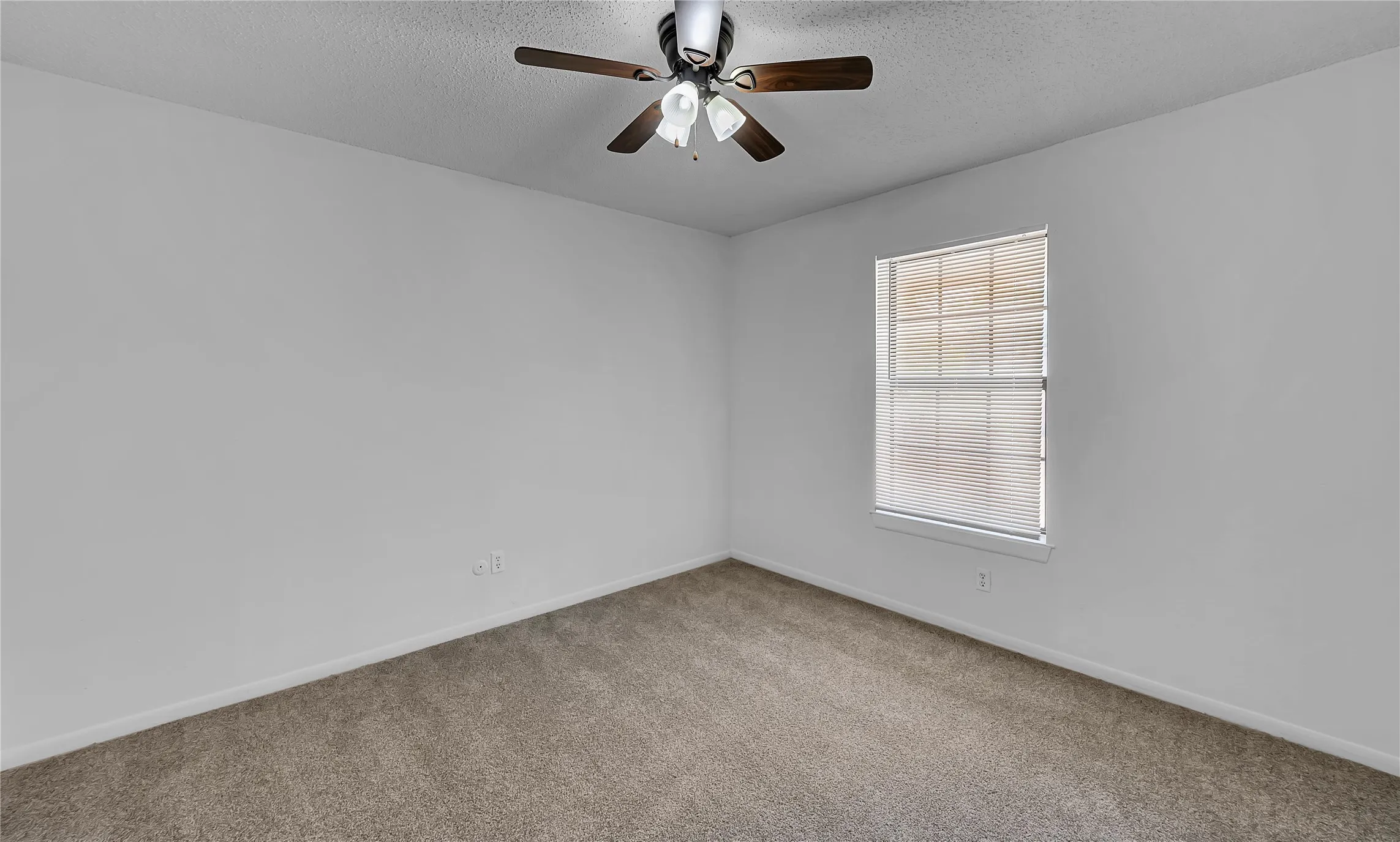 Neutral wall paint, carpeted flooring, window with blinds, and ceiling fan with light fixture