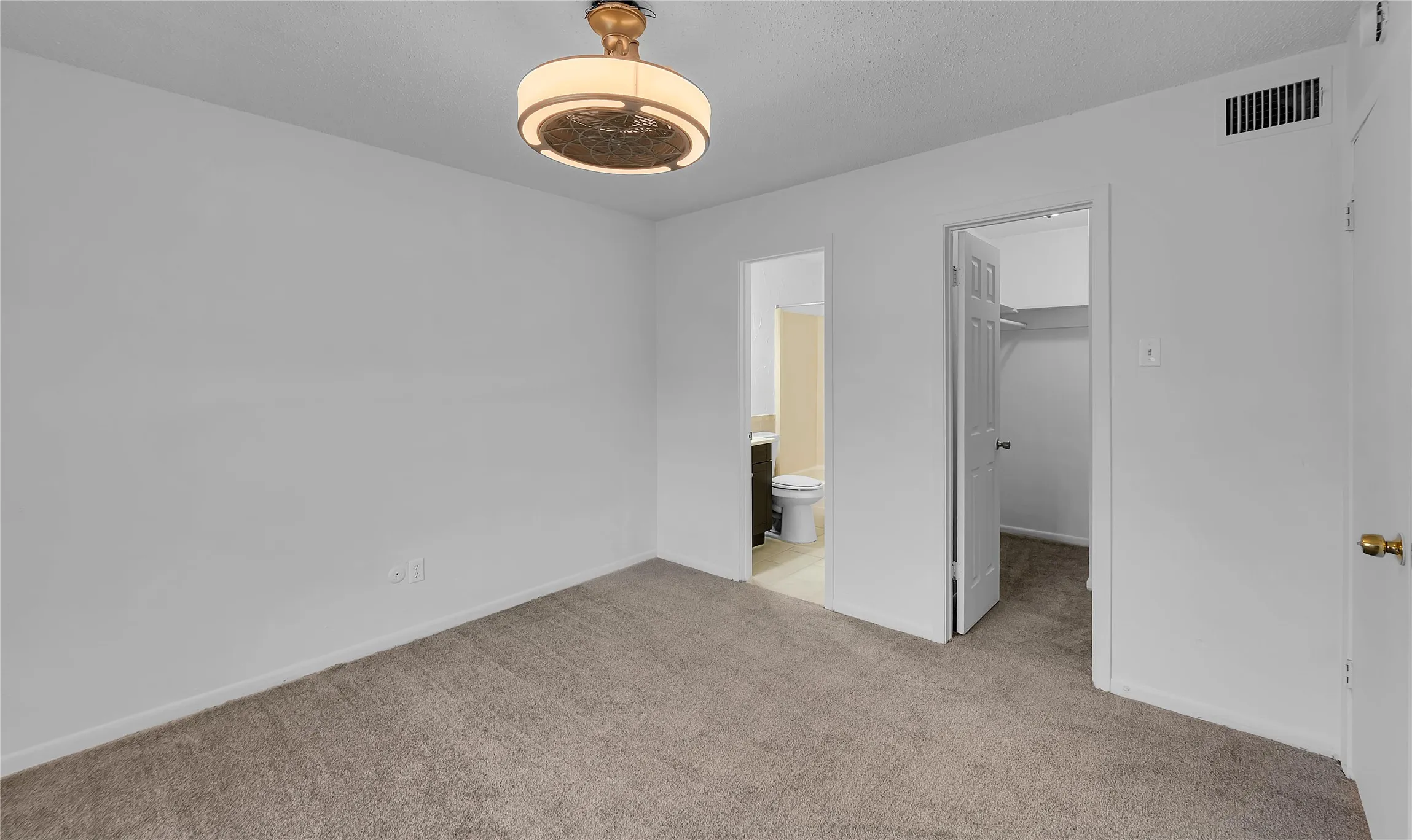 Neutral-toned wall-to-wall carpeting, overhead lighting fixture, and white painted walls