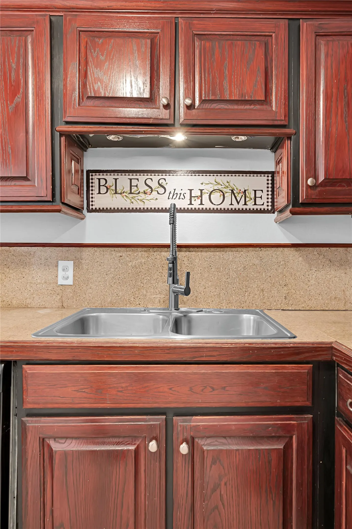 Wood-finish cabinetry with panel doors, dual basin stainless steel sink, and a modern pull-down faucet