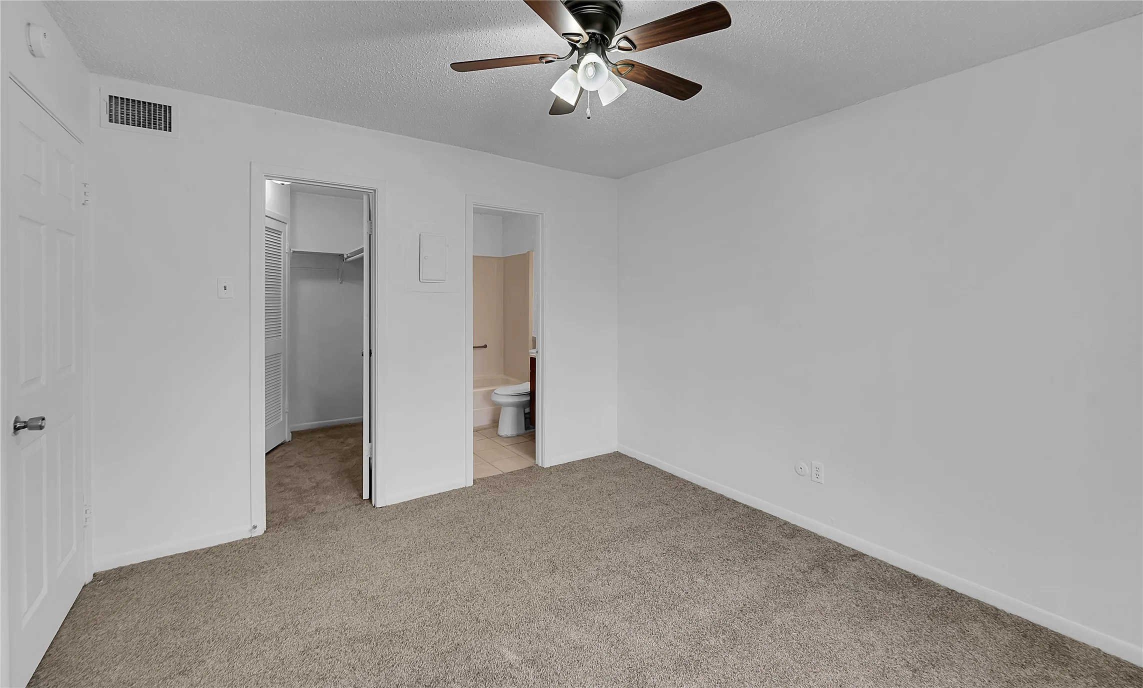 Neutral-toned carpeting, ceiling fan with integrated lighting, white interior doors, and a built-in closet