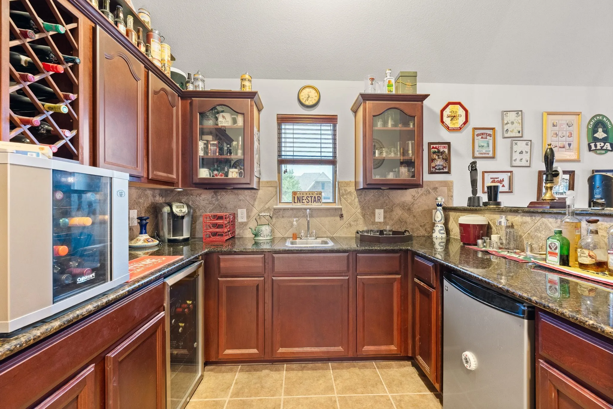 Fantastic Upstairs WET BAR with sink, granite countertops, serving bar, fridge, & wine coolers... YES, the fridge & wine coolers convey!! Conveniently located between Game & Media Rooms.
