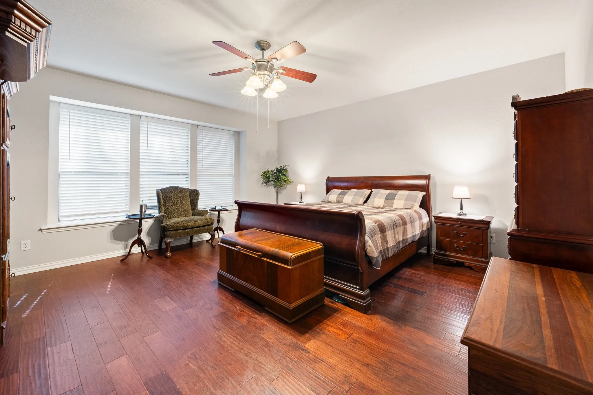 Spacious Primary Bedroom Retreat is DOWNSTAIRS, privately split from others, and features wood flooring, ceiling fan, and...