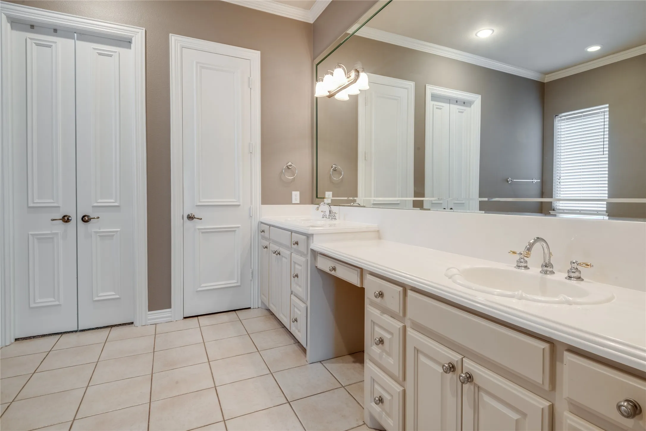 Double vanity with integrated sinks, extensive counter space, and integrated storage cabinetry