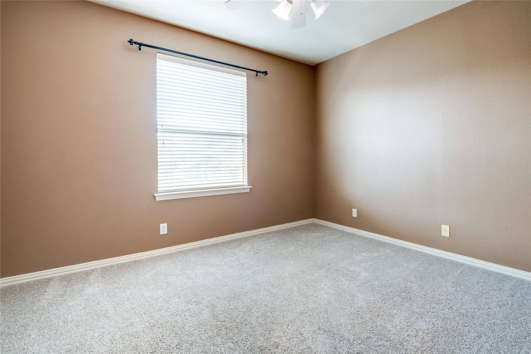 bedroom with Neutral-toned wall finish, expansive carpeting, window with horizontal blinds, and a ceiling fan