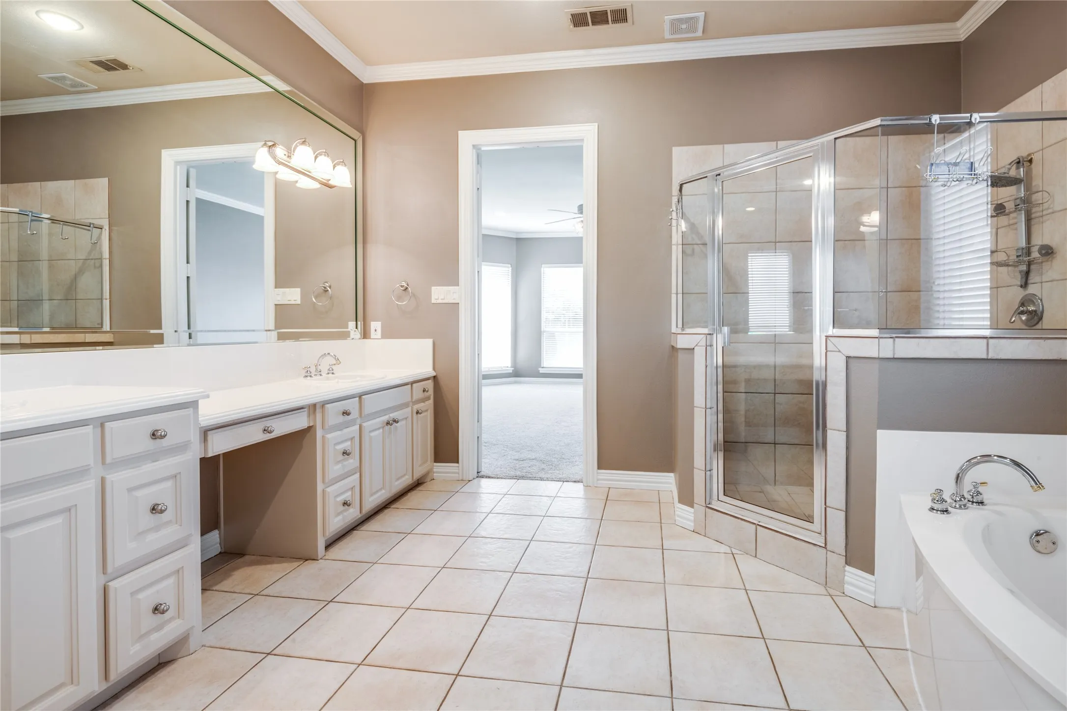 Double vanity with white cabinetry, tile flooring, glass-enclosed shower, and built-in soaking tub