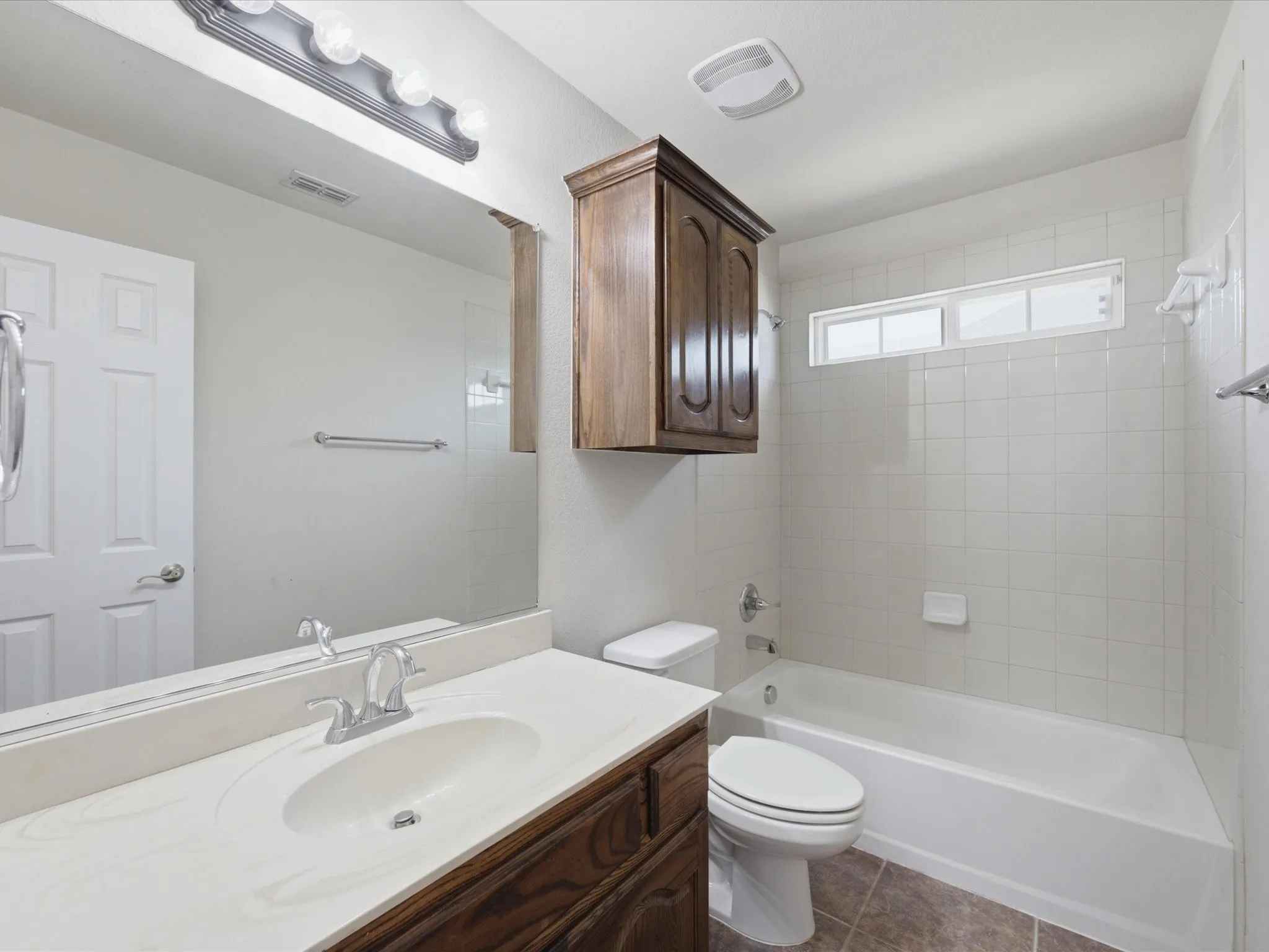 Vanity with an integrated sink, polished chrome faucet, and spacious mirror
