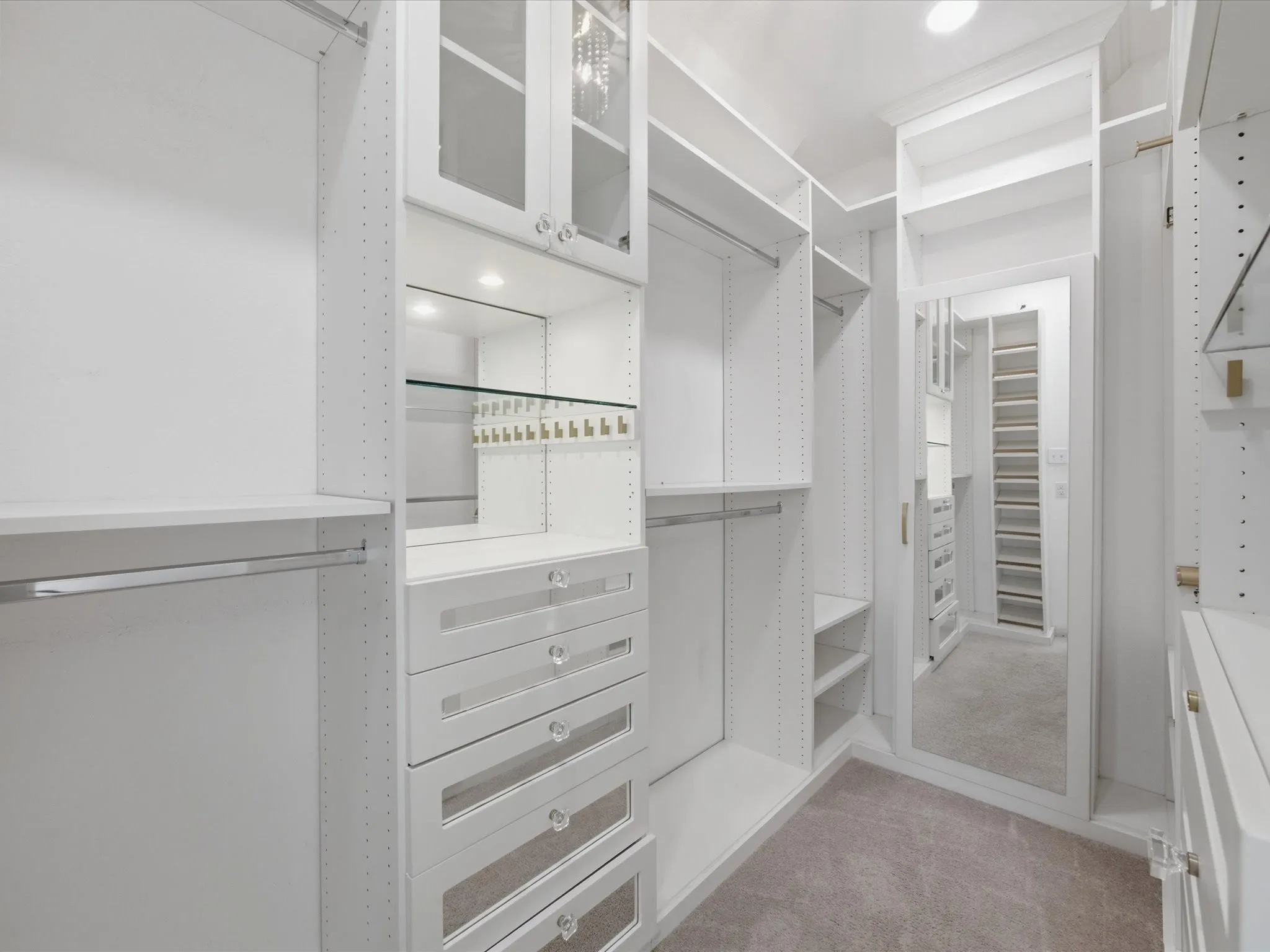 Custom closet system featuring built-in shelving, hanging rods, and integrated drawers with clear pulls
