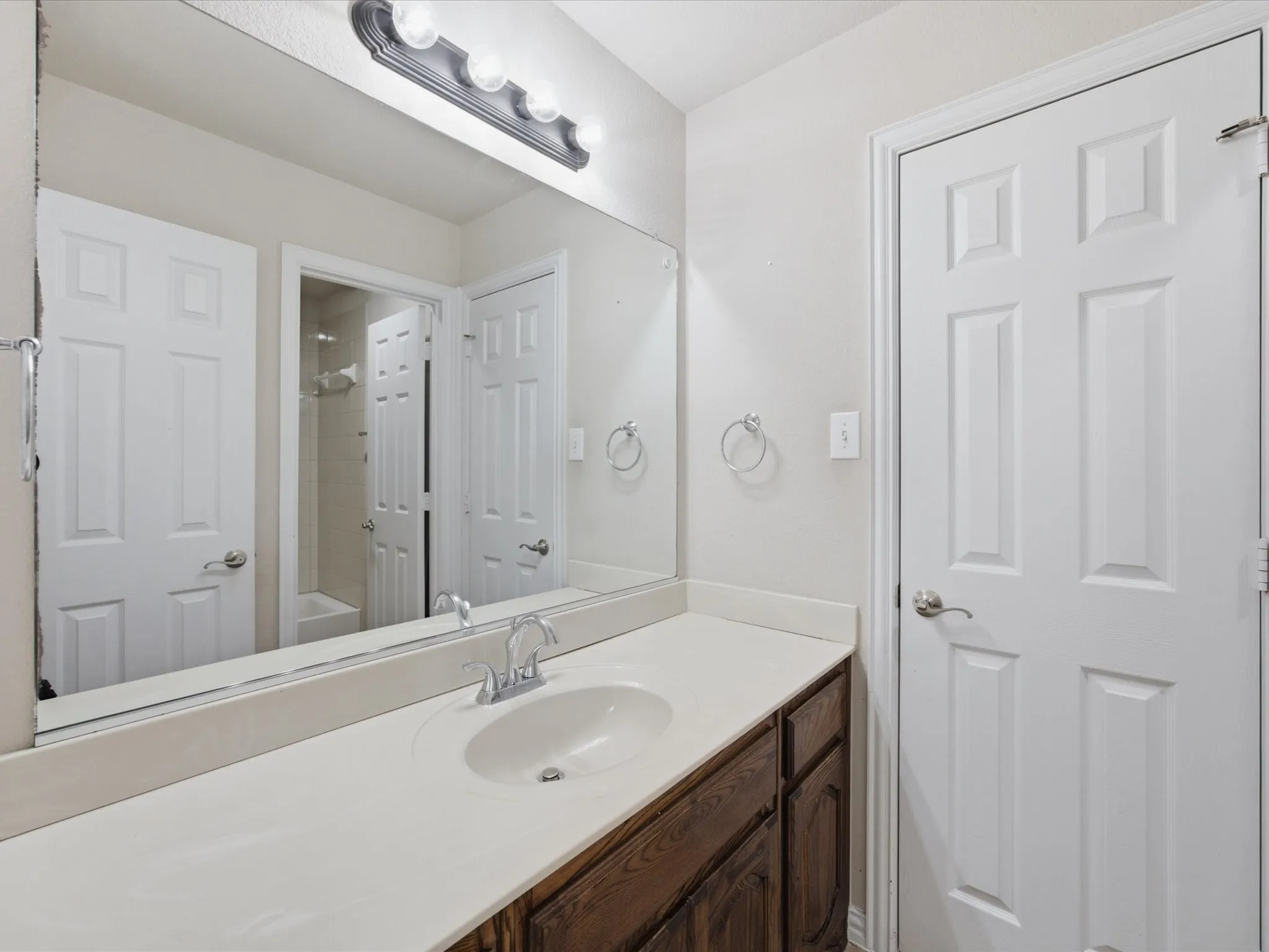 Vanity with an integrated sink, polished chrome faucet, and wood-finish cabinetry