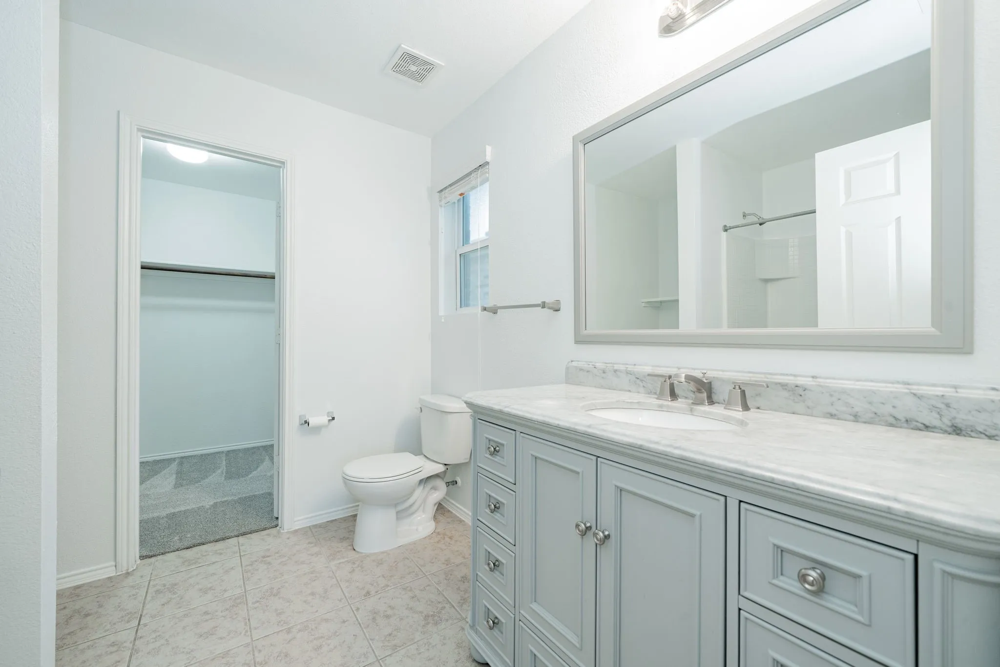 Bathroom featuring vanity, a spacious closet, and tile patterned flooring