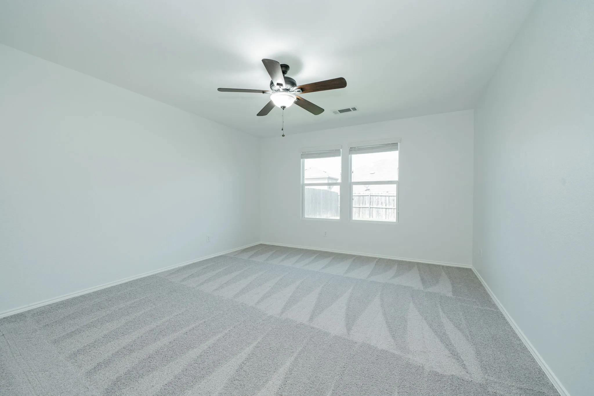Spare room featuring light colored carpet and ceiling fan