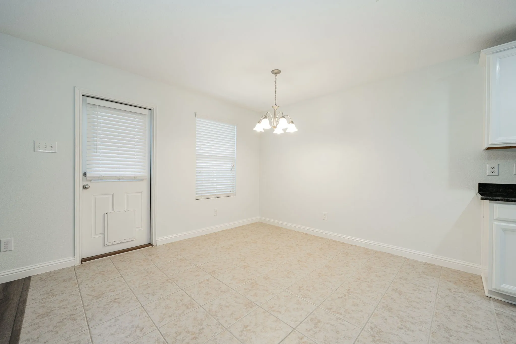 Unfurnished dining area with a chandelier and light tile patterned flooring