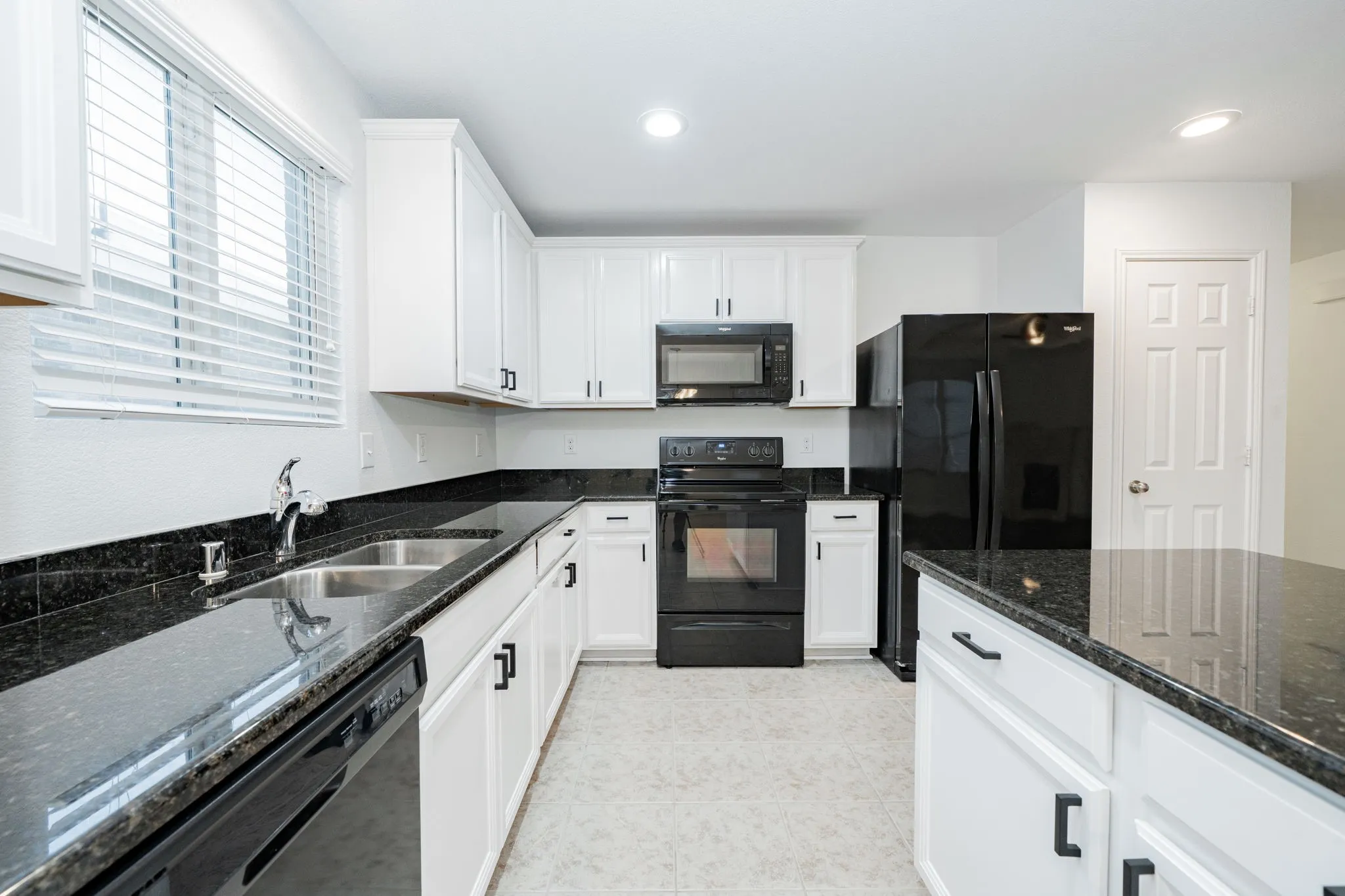 Kitchen featuring black appliances, white cabinets, dark stone countertops, recessed lighting, and light tile patterned flooring