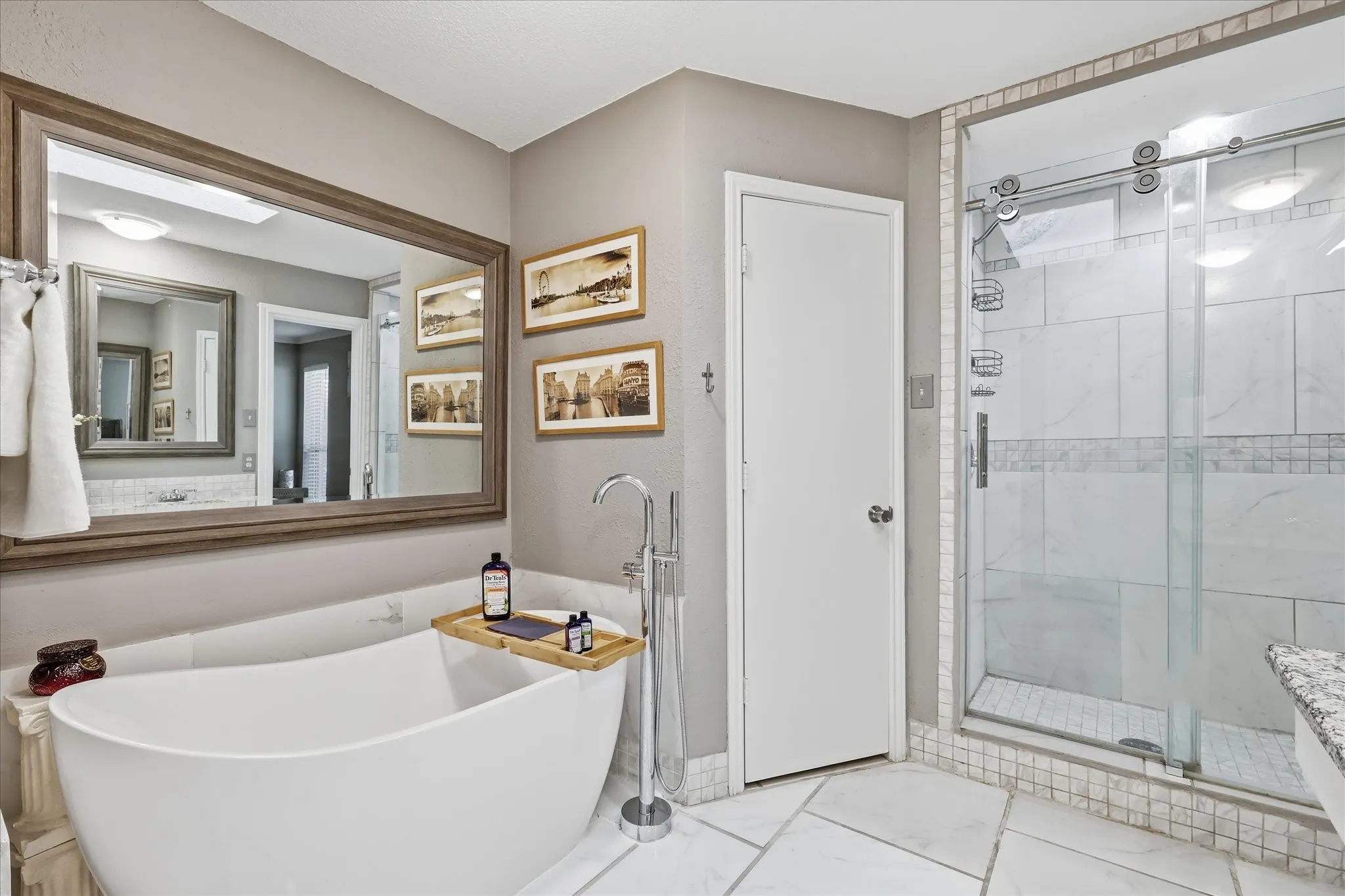 Primary bathroom with frameless shower and freestanding tub.