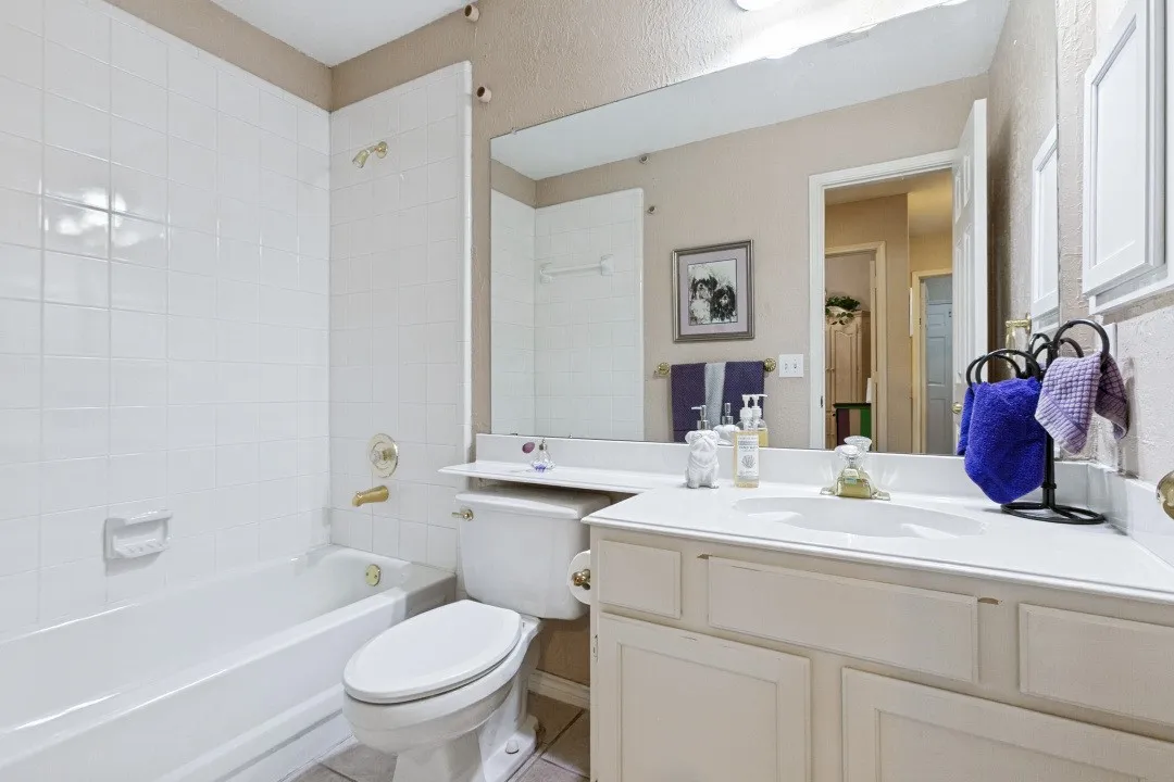 White tiled tub surround with brass-finish fixtures