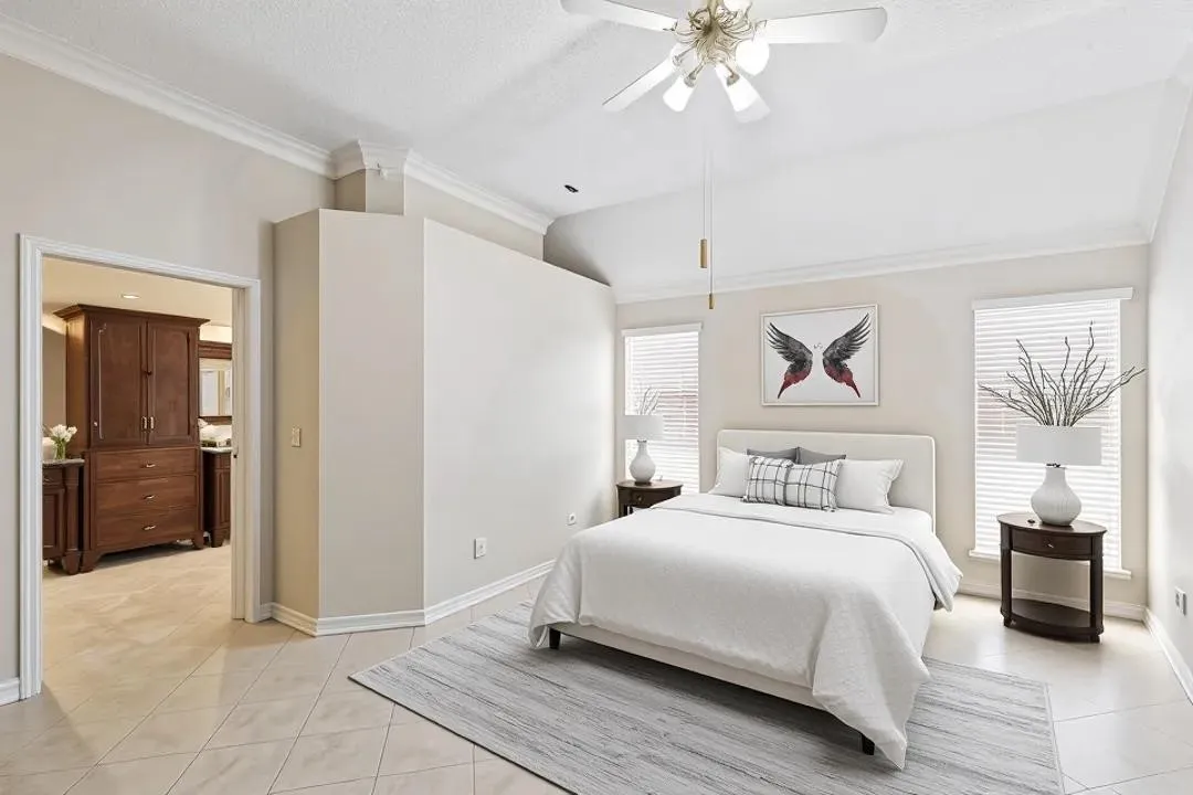 Vaulted ceiling with ceiling fan, tile flooring, crown molding, and two windows with blinds