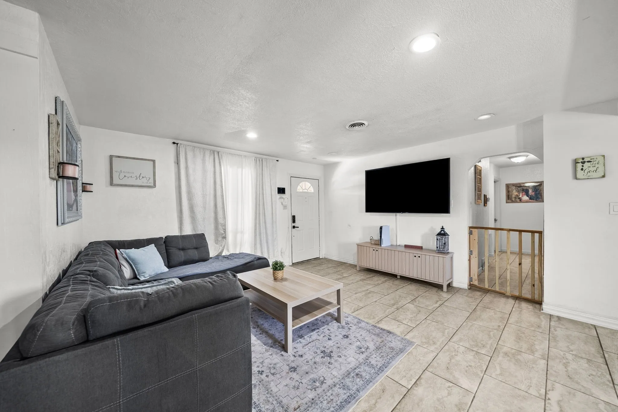 Recessed ceiling lighting, tiled flooring, white interior door with decorative glass, white walls