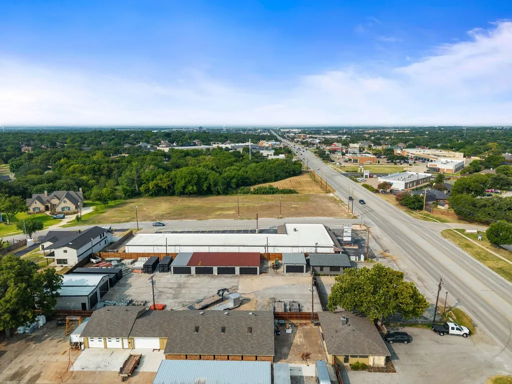 Multiple commercial structures with varied rooflines and a paved lot