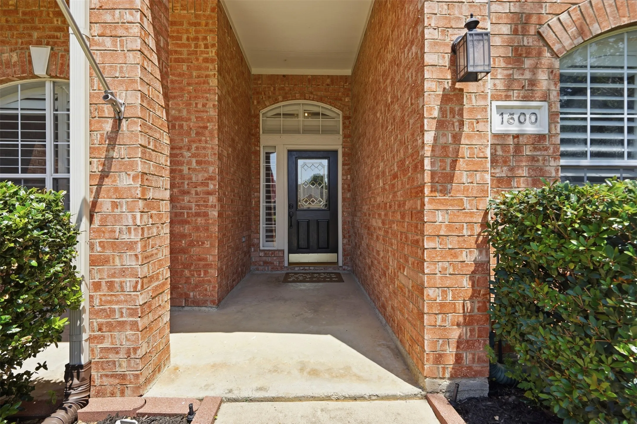 Covered front porch with a decorative glass entry door creates a warm first impression.