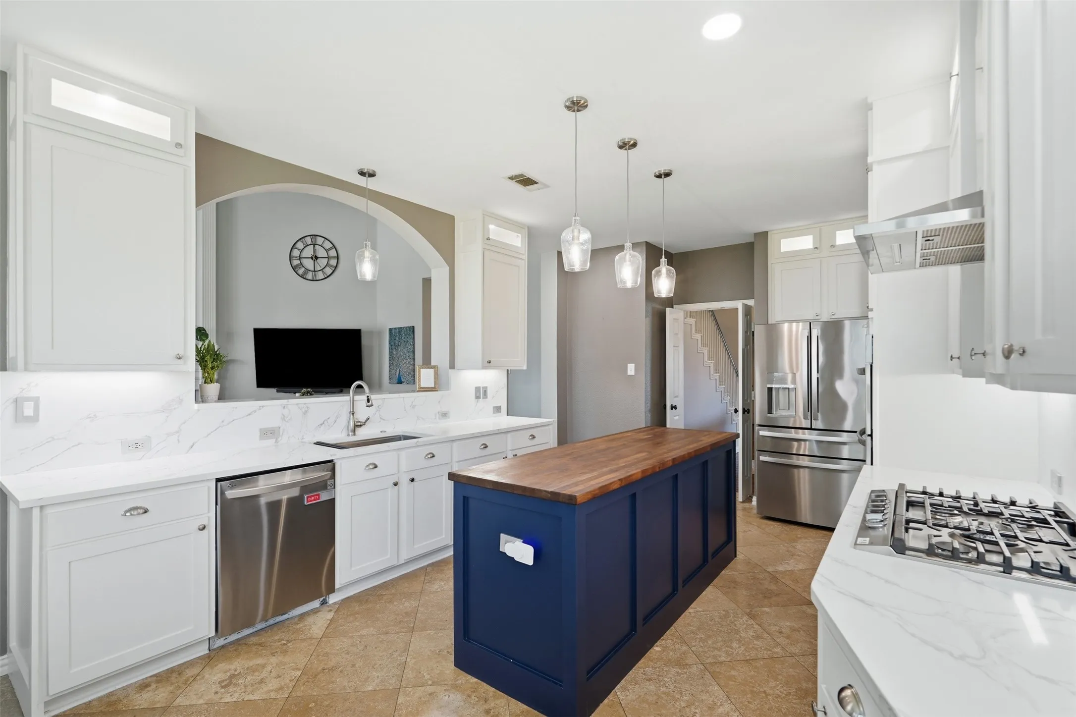 Remodeled kitchen with white cabinets, quartz countertops, and new appliances.