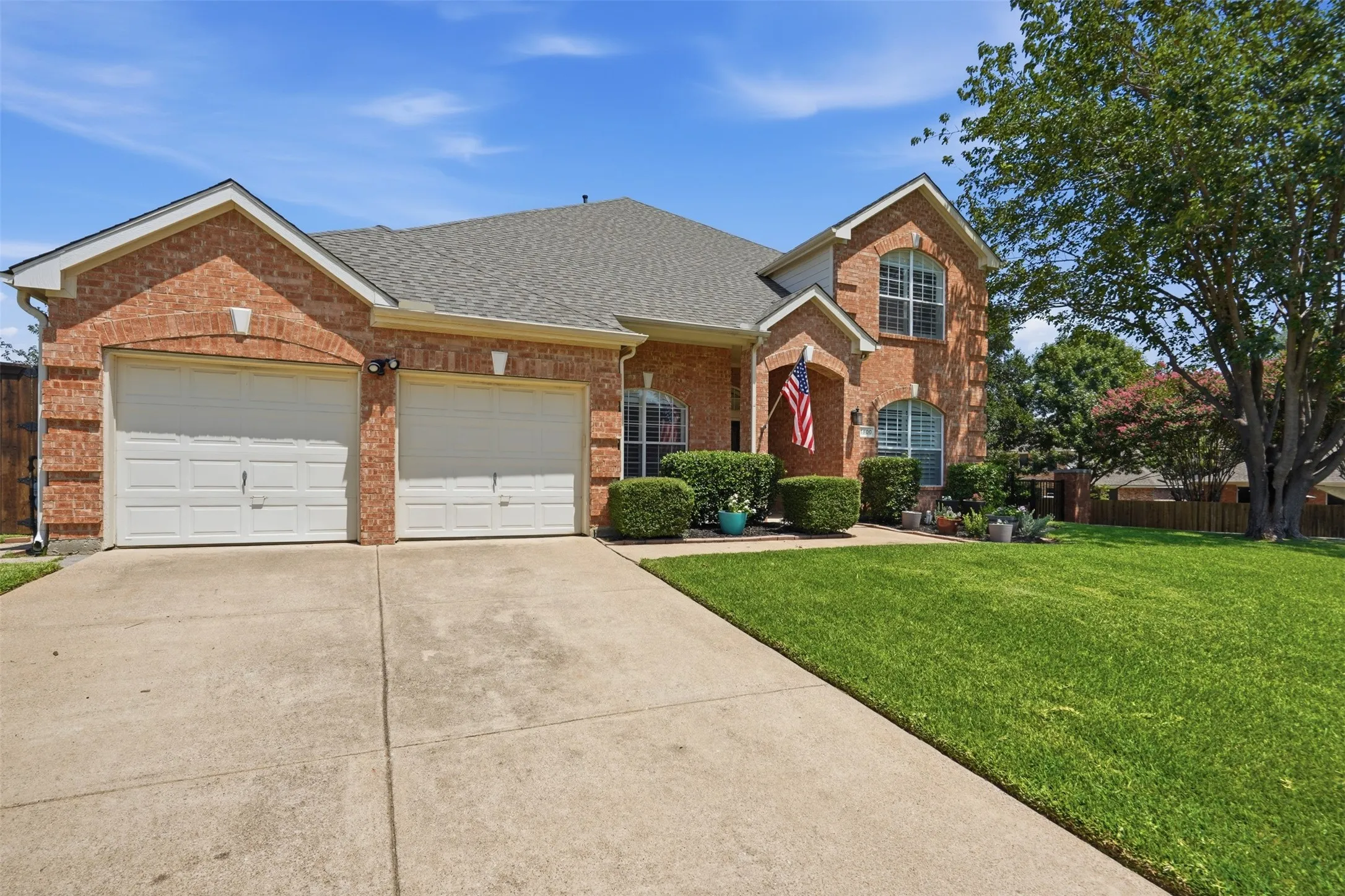 Beautifully maintained home showcasing timeless architecture, lush landscaping, and an inviting covered front entry.