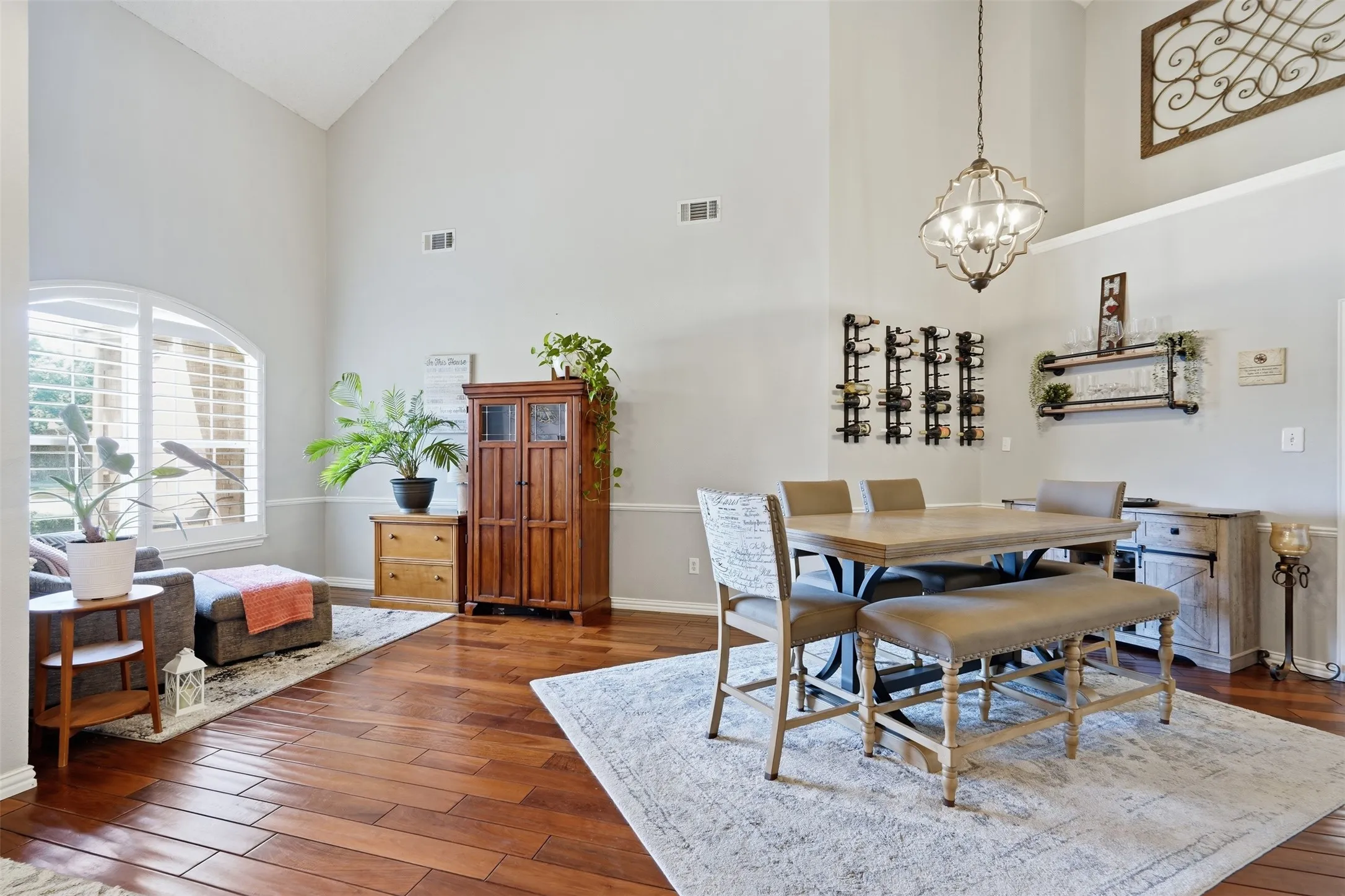 Formal living and dining areas with high ceilings, designer light fixtures, hardwood floors, and neutral paint colors.