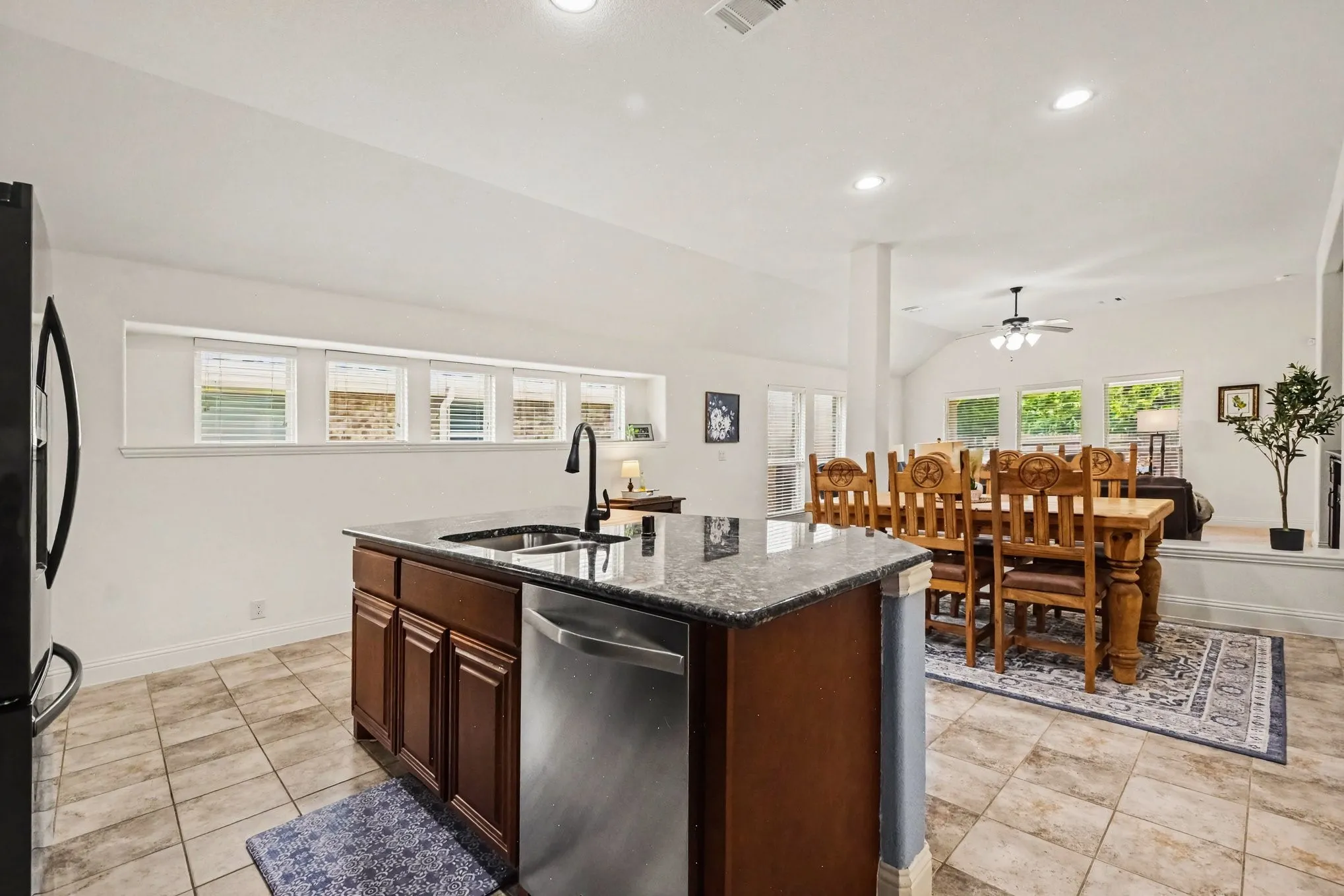 Kitchen island with an undermount sink, gooseneck faucet, and stainless steel dishwasher