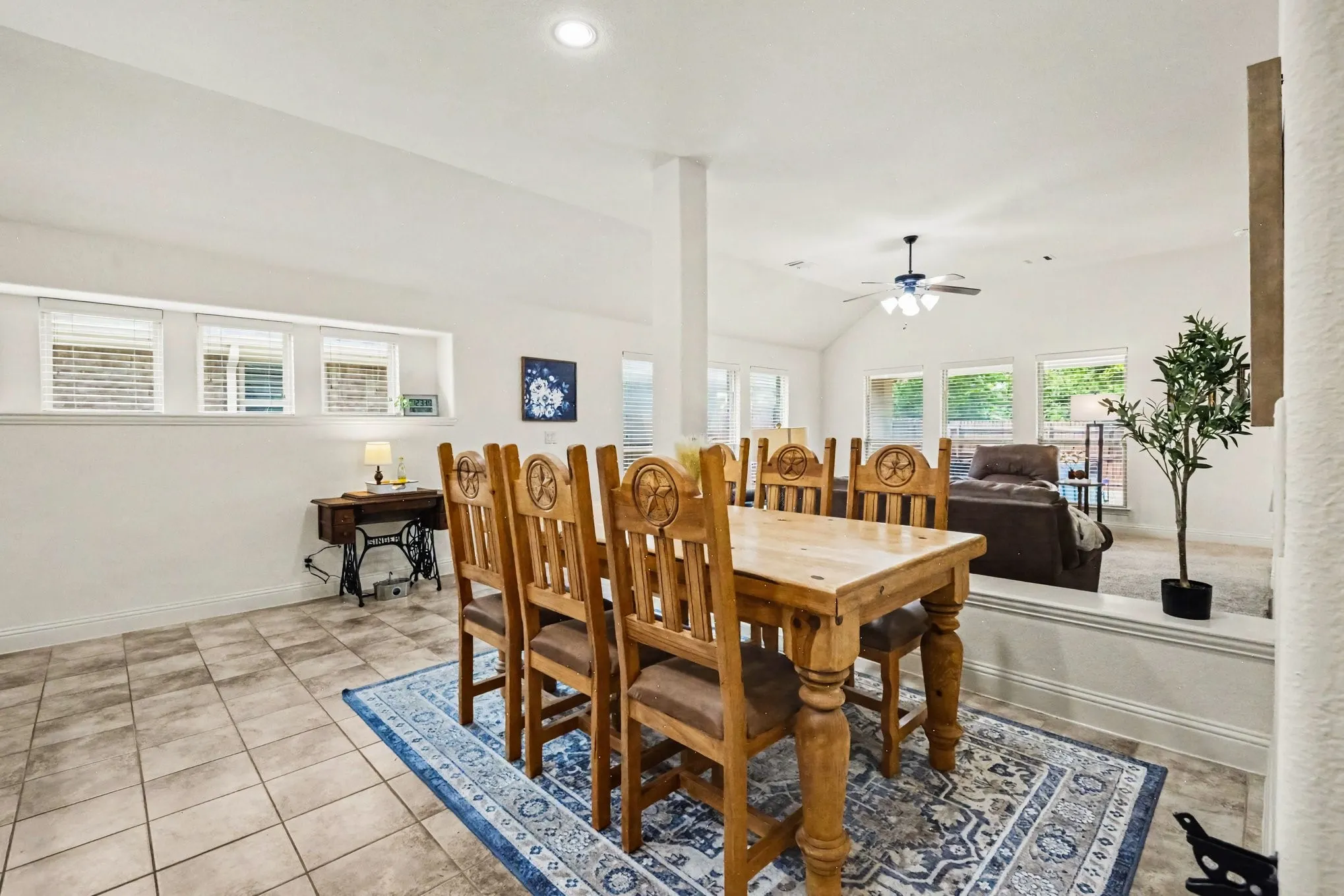 Ceramic tile flooring, white walls, recessed ceiling lighting, three windows with blinds, and a built-in wall partition