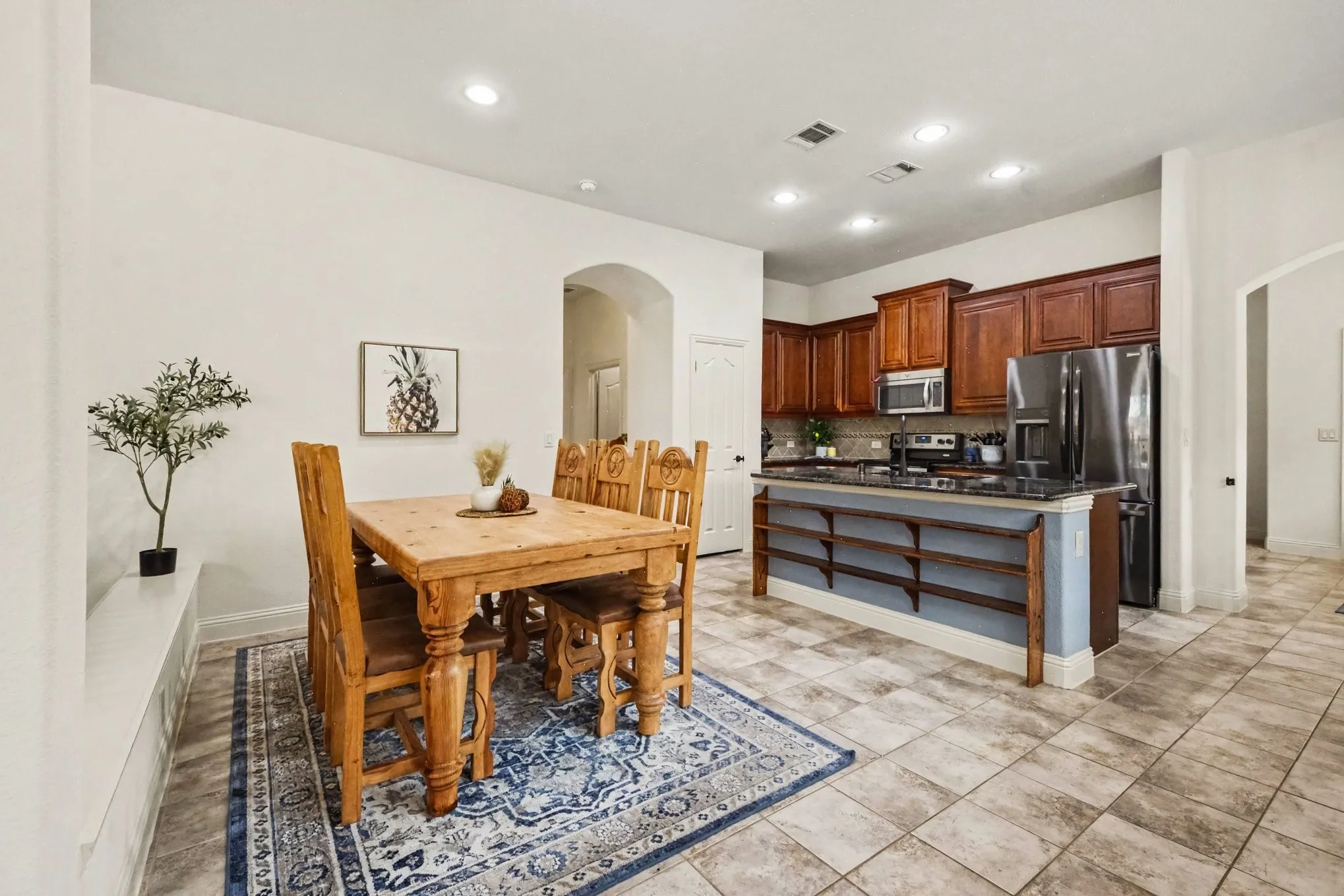 Kitchen featuring dark wood cabinetry, stainless steel appliances, and a tiled backsplash