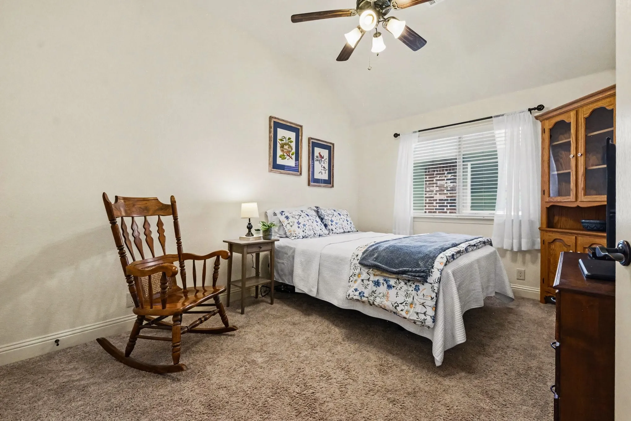 Vaulted ceiling with a ceiling fan, window with blinds, and wall-to-wall carpeting