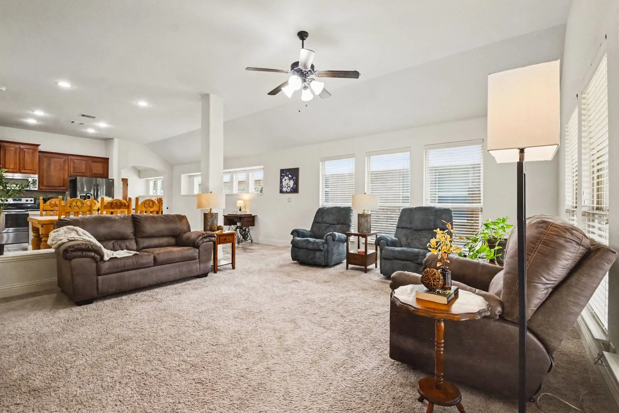 Open-concept living space featuring vaulted ceilings, recessed lighting, and a ceiling fan