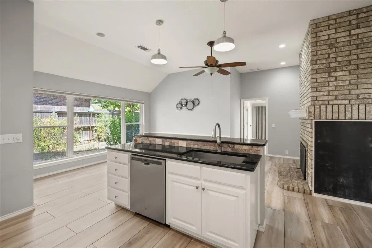 Kitchen island with dark countertop and stainless steel dishwasher