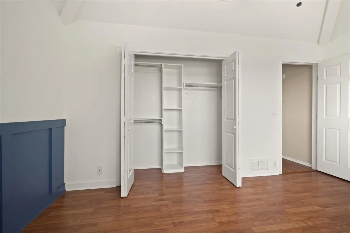 Wood-finish flooring, white walls, and a blue wainscoting accent wall