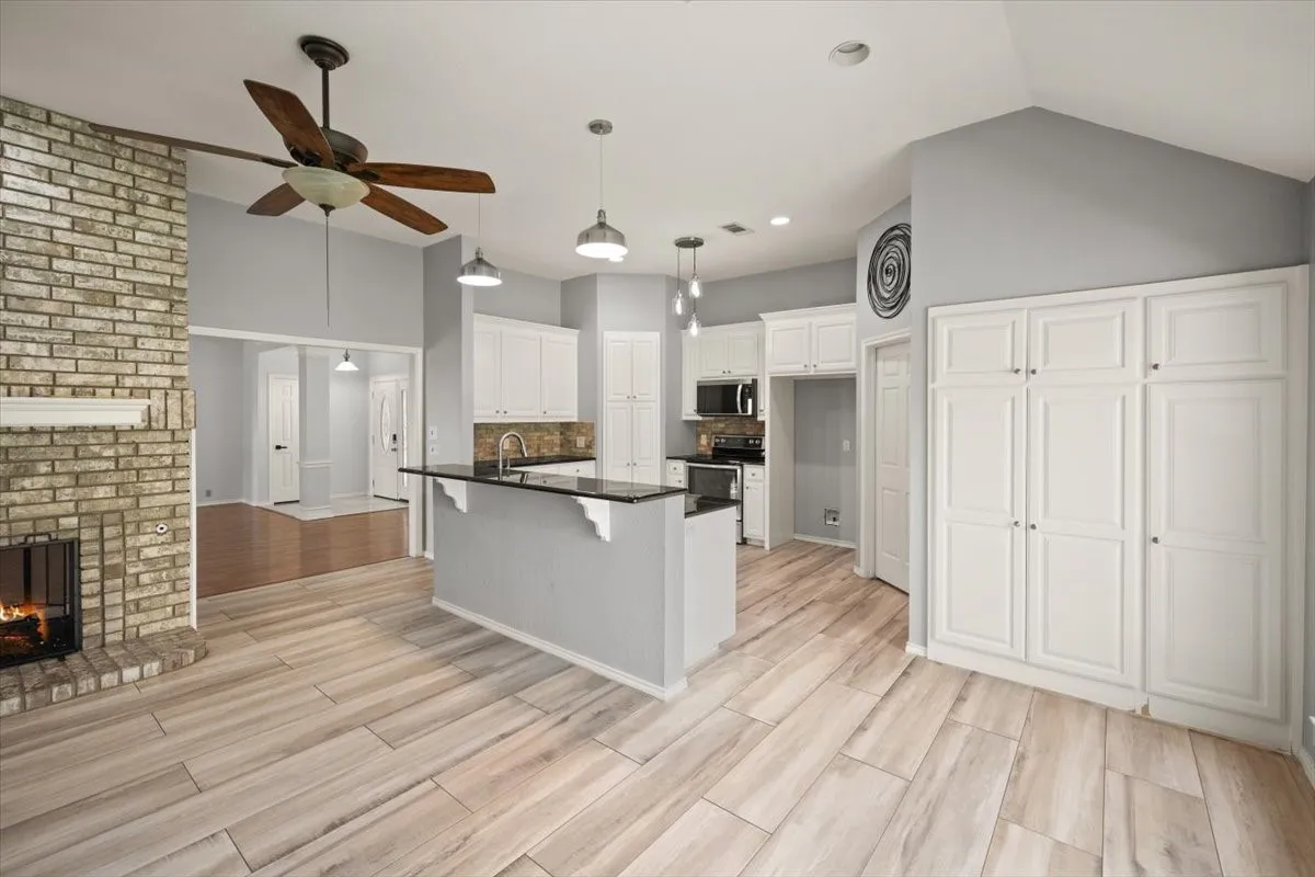 Vaulted ceilings, a brick-surround fireplace, and wood-finish flooring