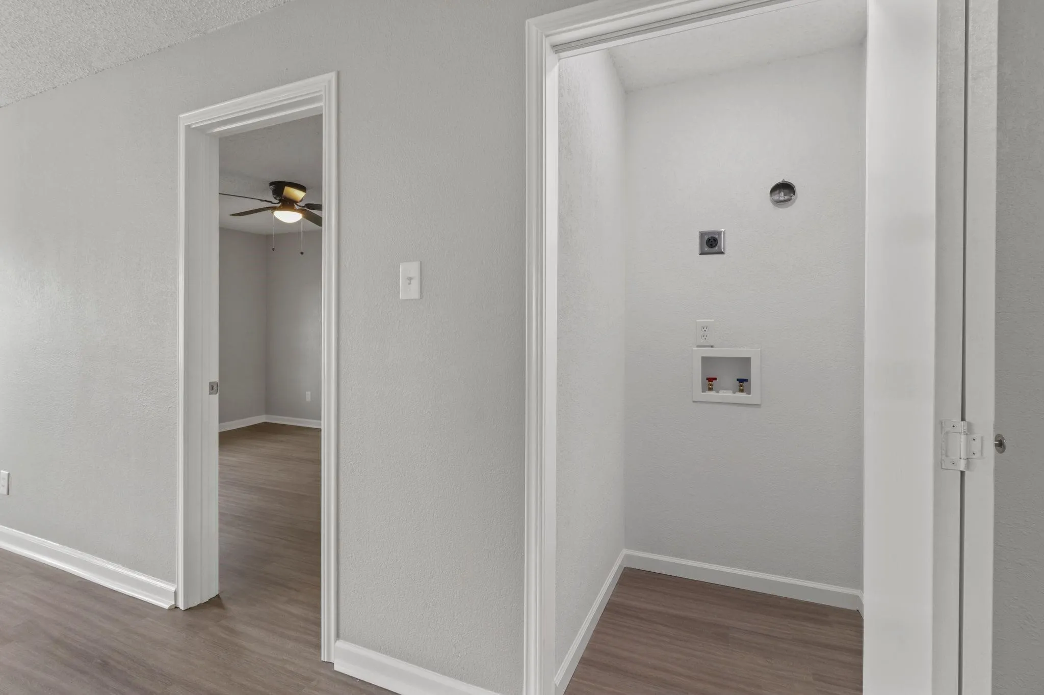 Dedicated laundry area with utility hookups and wood-finish flooring