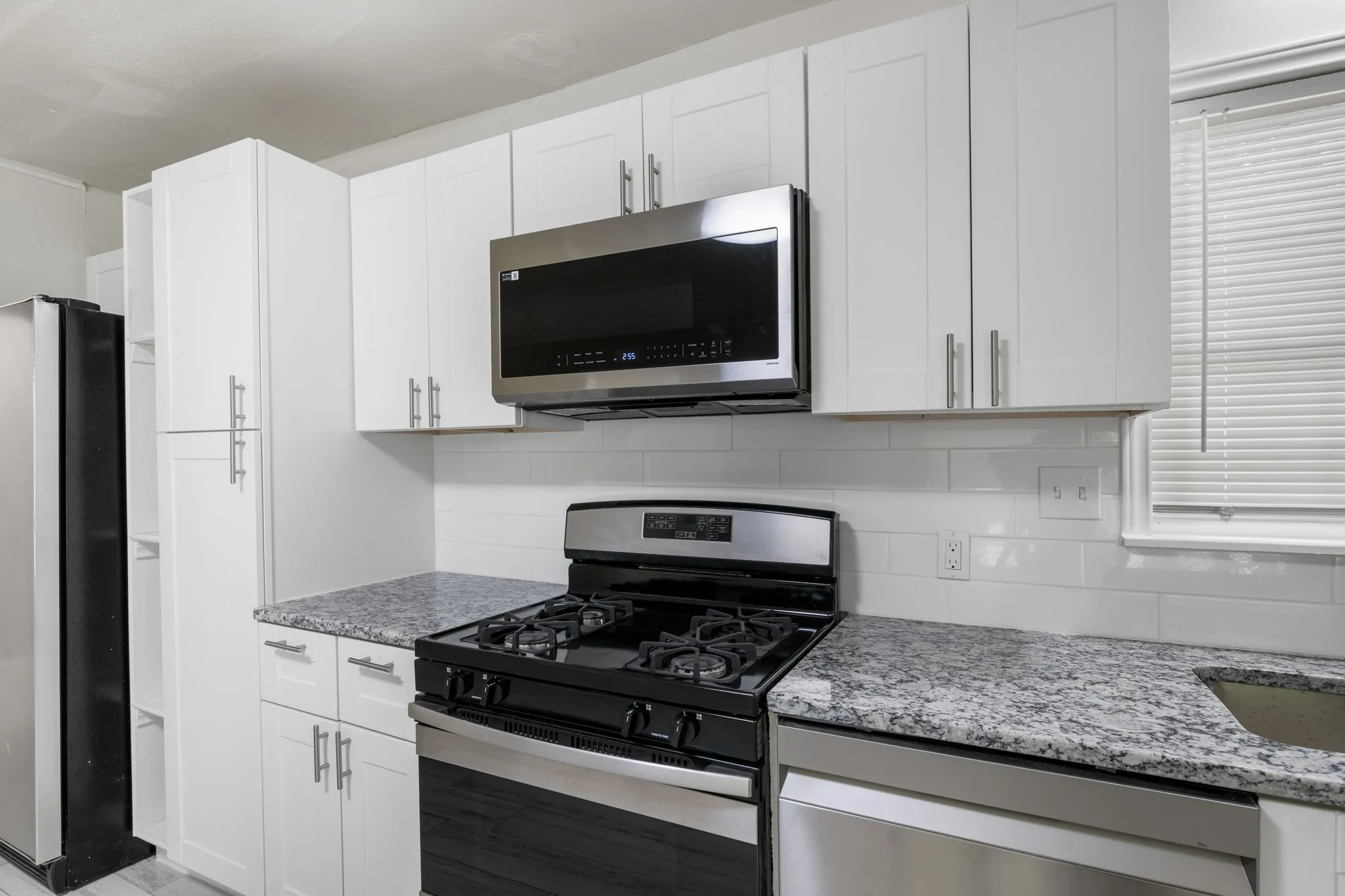 Gas range in kitchen with microwave built in.