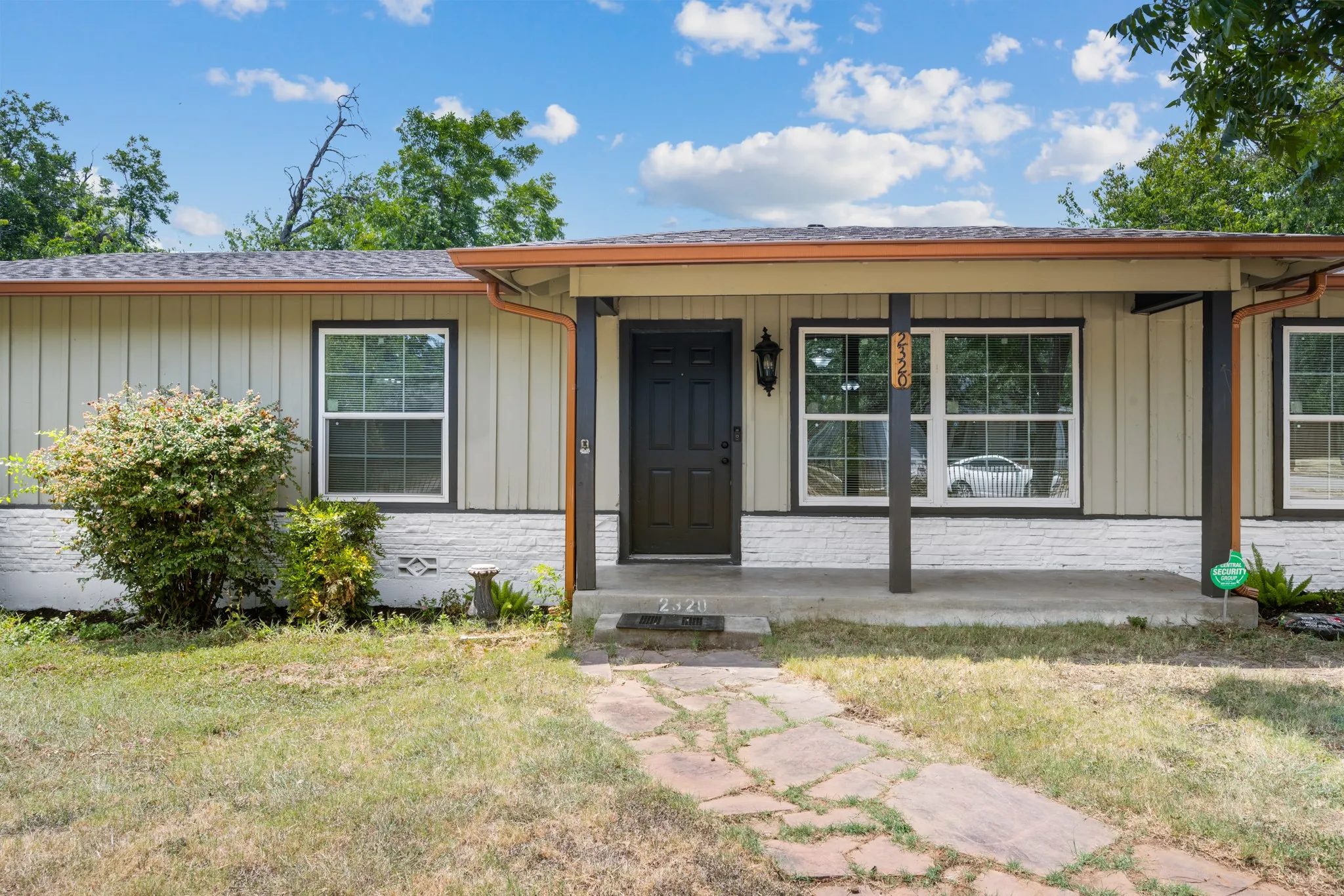 Inviting covered front porch with a charming stone walkway and updated exterior finishes.