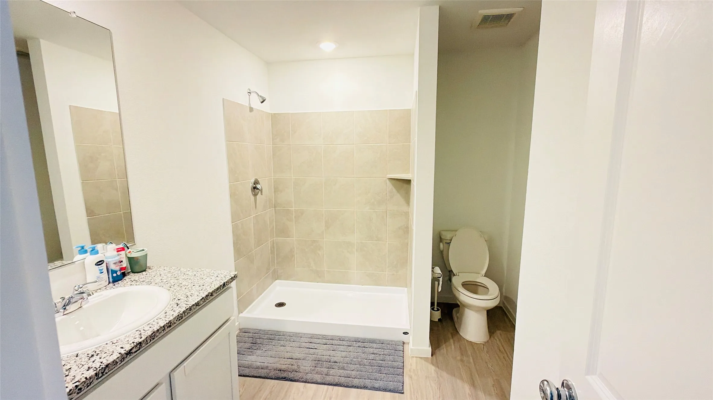 Vanity with a speckled countertop, integrated sink, and chrome faucet