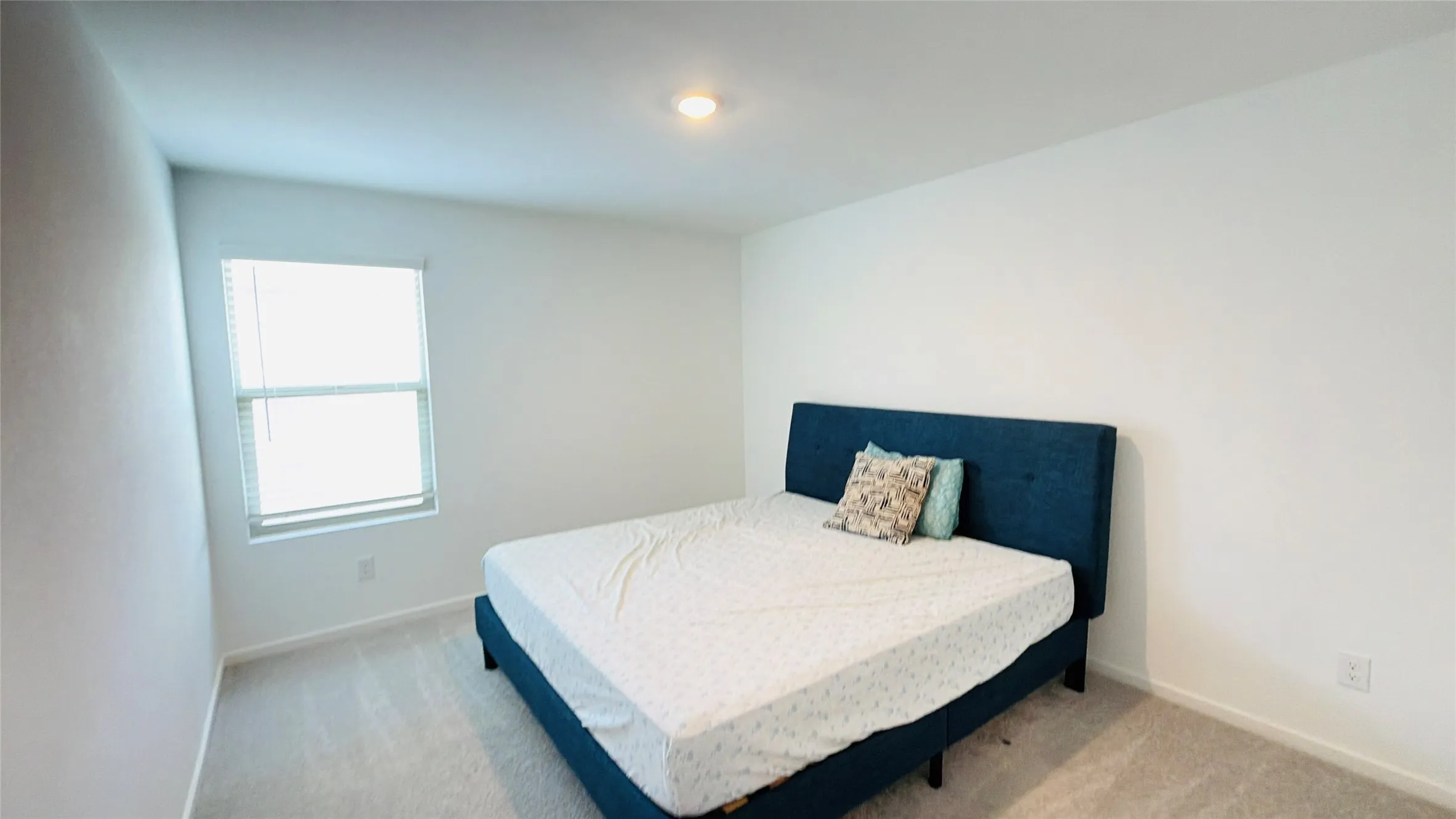 Recessed ceiling lighting, light-toned wall finishes, carpet flooring, and a single window with blinds