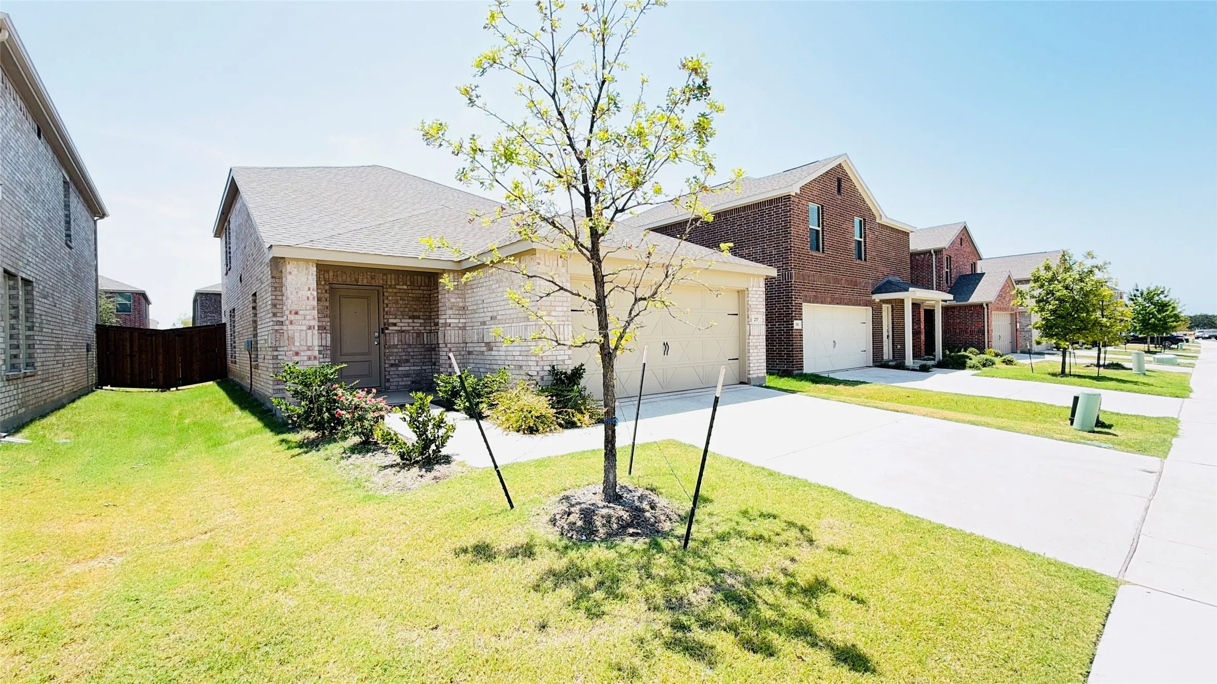 Brick exterior with an attached garage, covered entry, and a paved​​‌​​​​‌​​‌‌​‌‌​​​‌‌​‌​‌​‌​​​‌​​ driveway