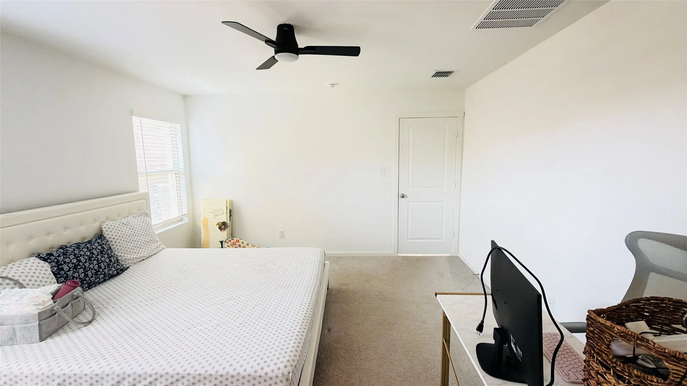 White painted walls, carpeted flooring, a ceiling-mounted fan, a window with blinds, and a paneled interior door