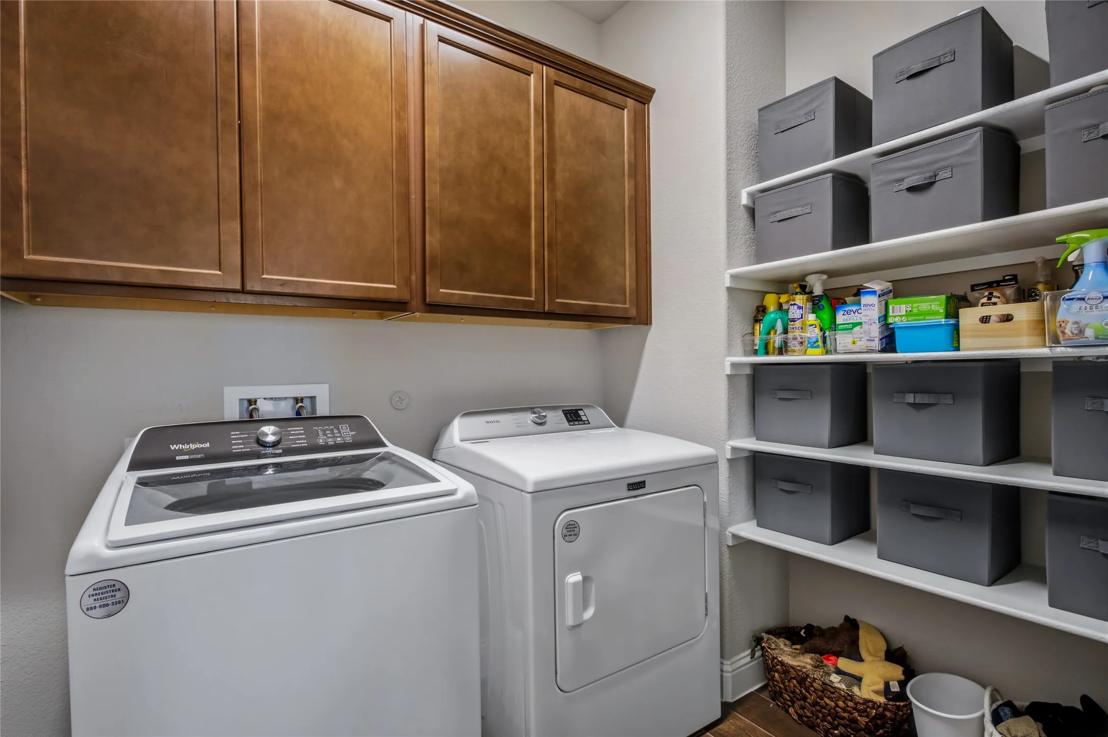 Dedicated laundry space with cabinetry, utility connections, and additional storage.