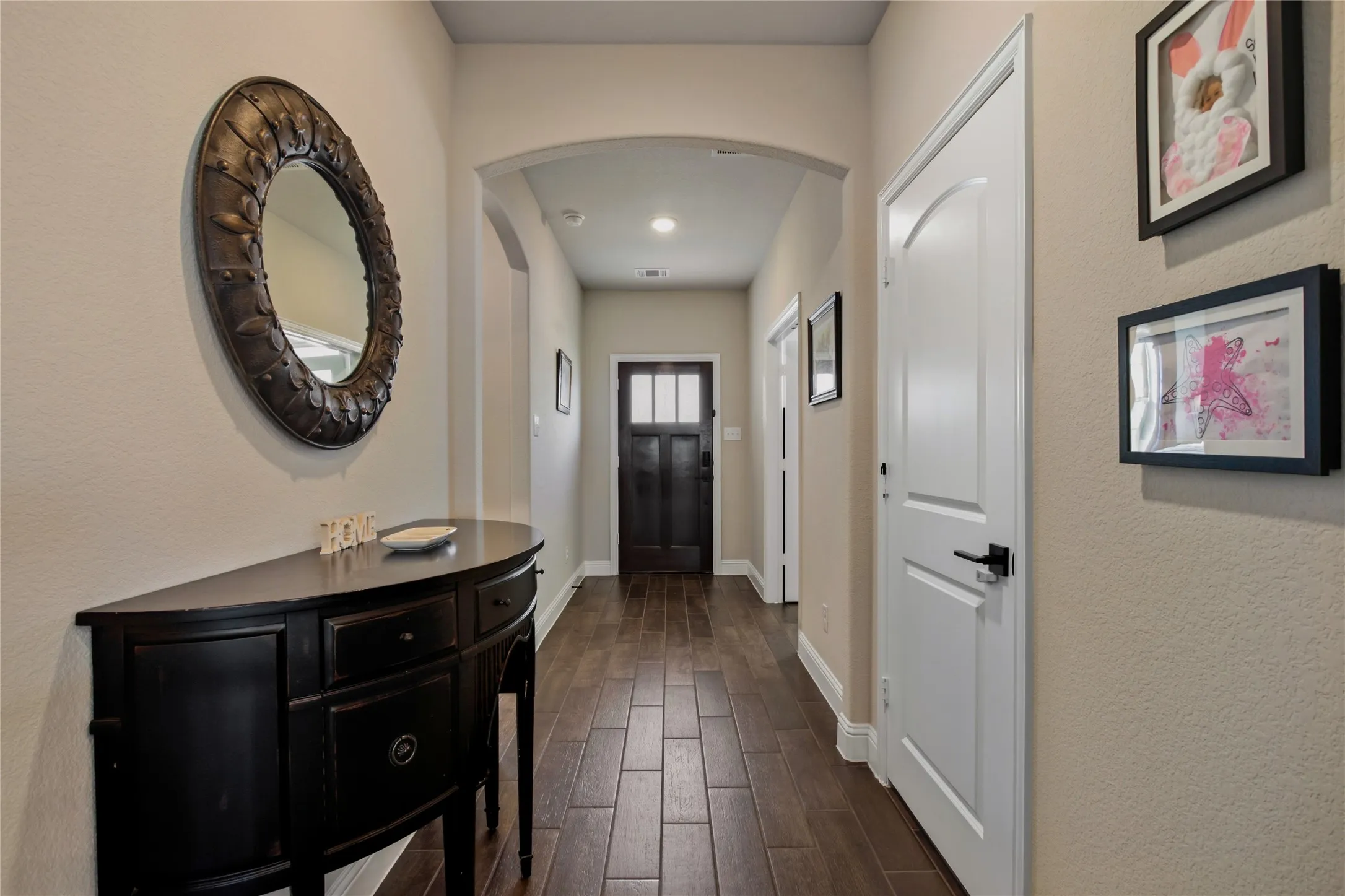 Welcoming foyer with wood-look flooring and easy access to the home's main living spaces.