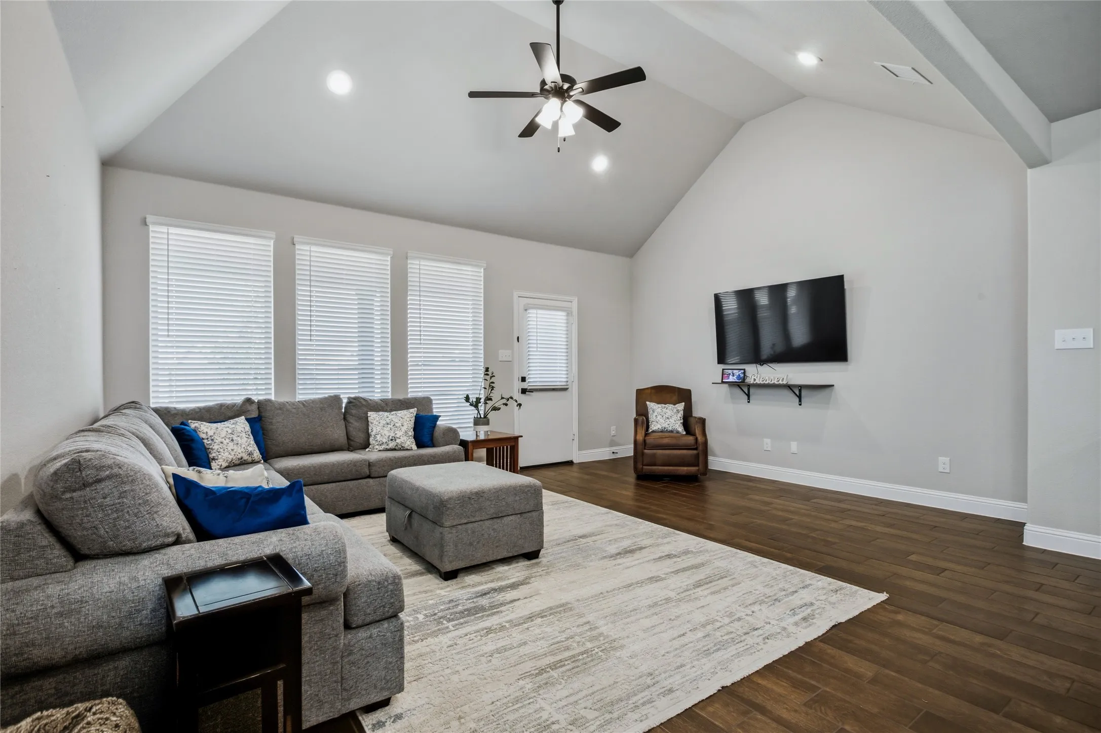 Generous living room with large windows, high ceilings, and an easy connection to the kitchen.