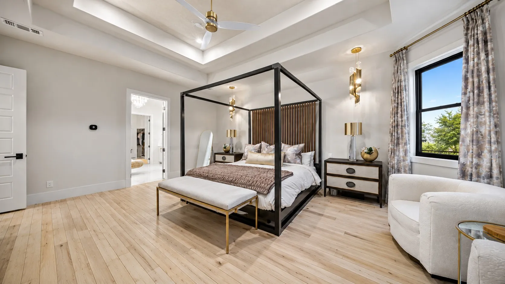Master suite with hardwoods, sitting area, motorized black-out shades, raised lighted ceilings, and designer fixtures.
