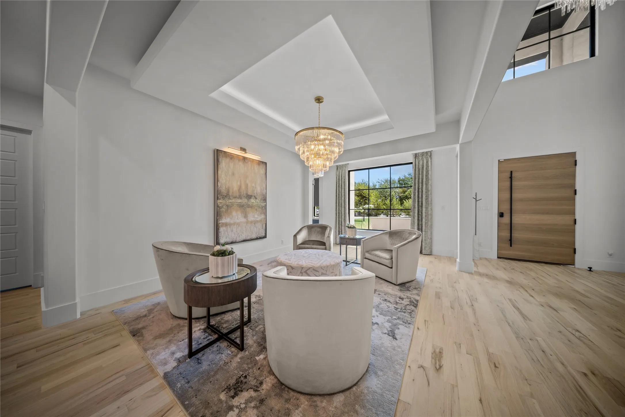 The large foyer has a flex area designed with a raised and lighted ceiling to serve as a conversation room or formal dining, convenient to the kitchen, bar, and media rooms.