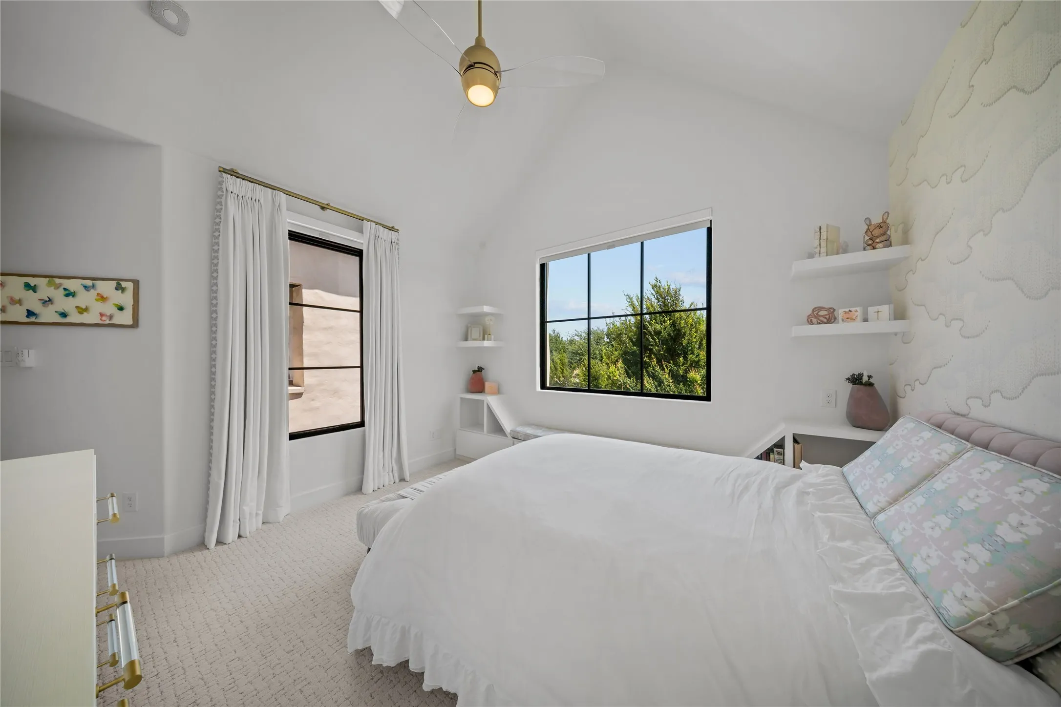 Upstairs secondary bedroom with high ceiling and custom fans.