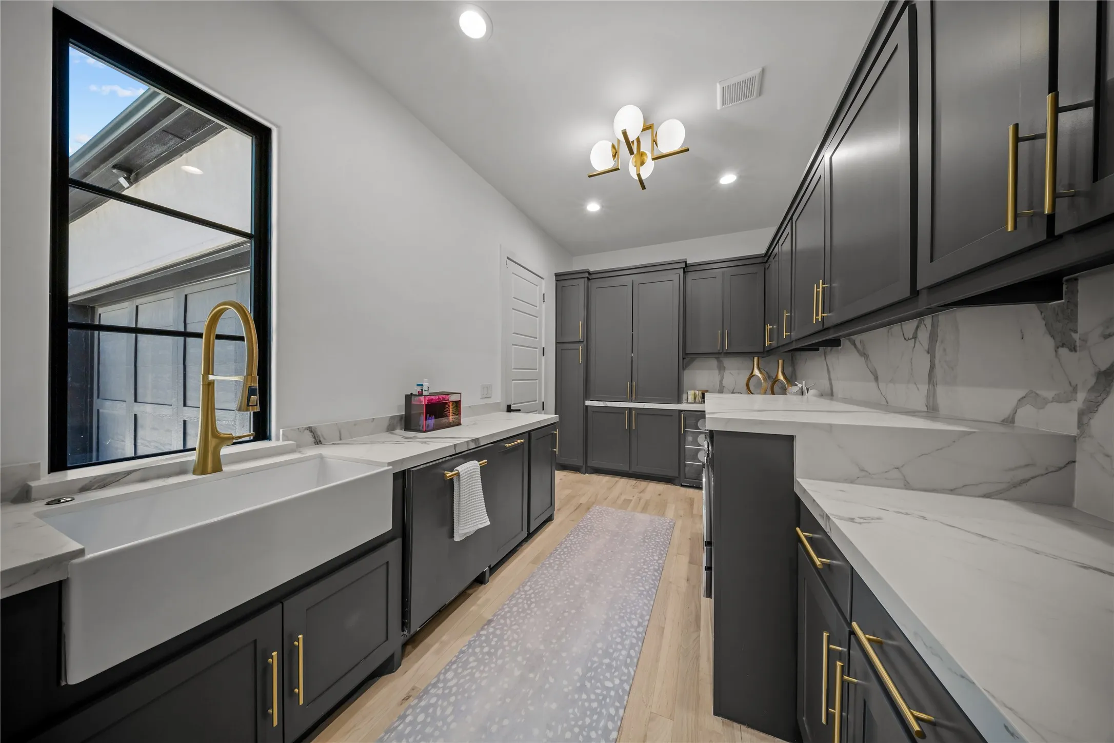 Multi-purpose utility room with custom cabinets, farm sink, filtered water bottle dispenser, and room for all your appliances hidden away.
